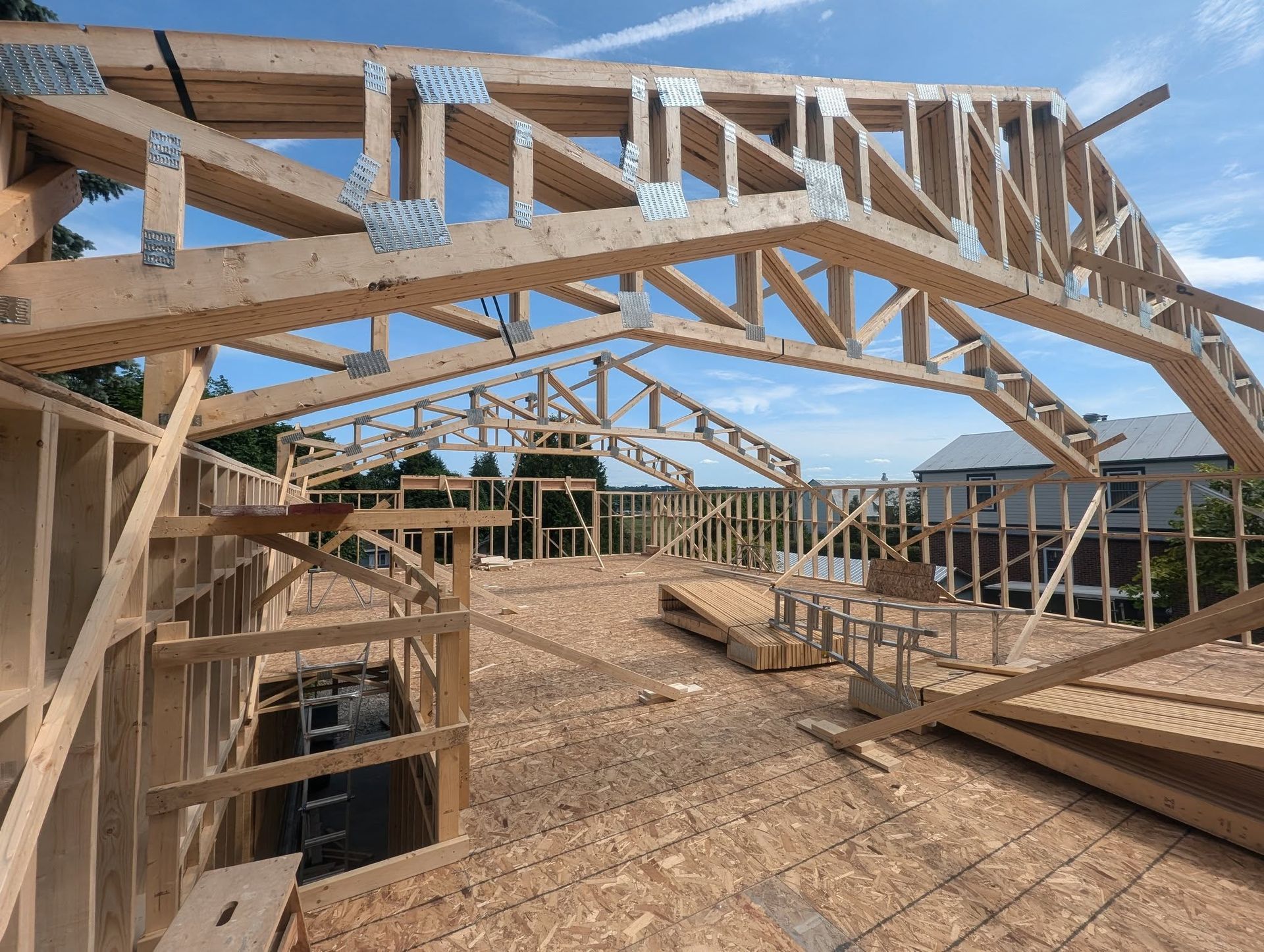 Une grande structure en bois est en cours de construction par une journée ensoleillée.