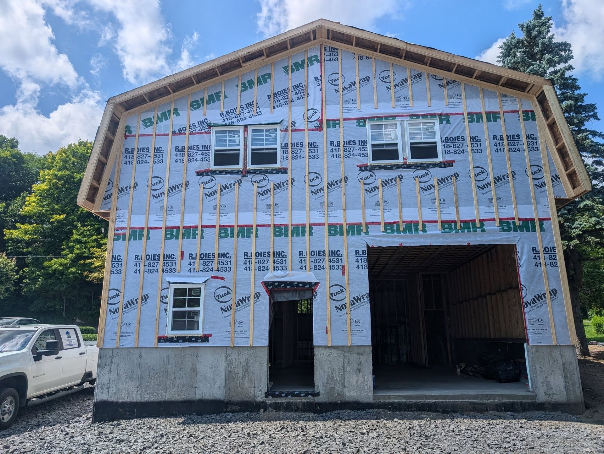 Un camion blanc est garé devant un bâtiment en construction.