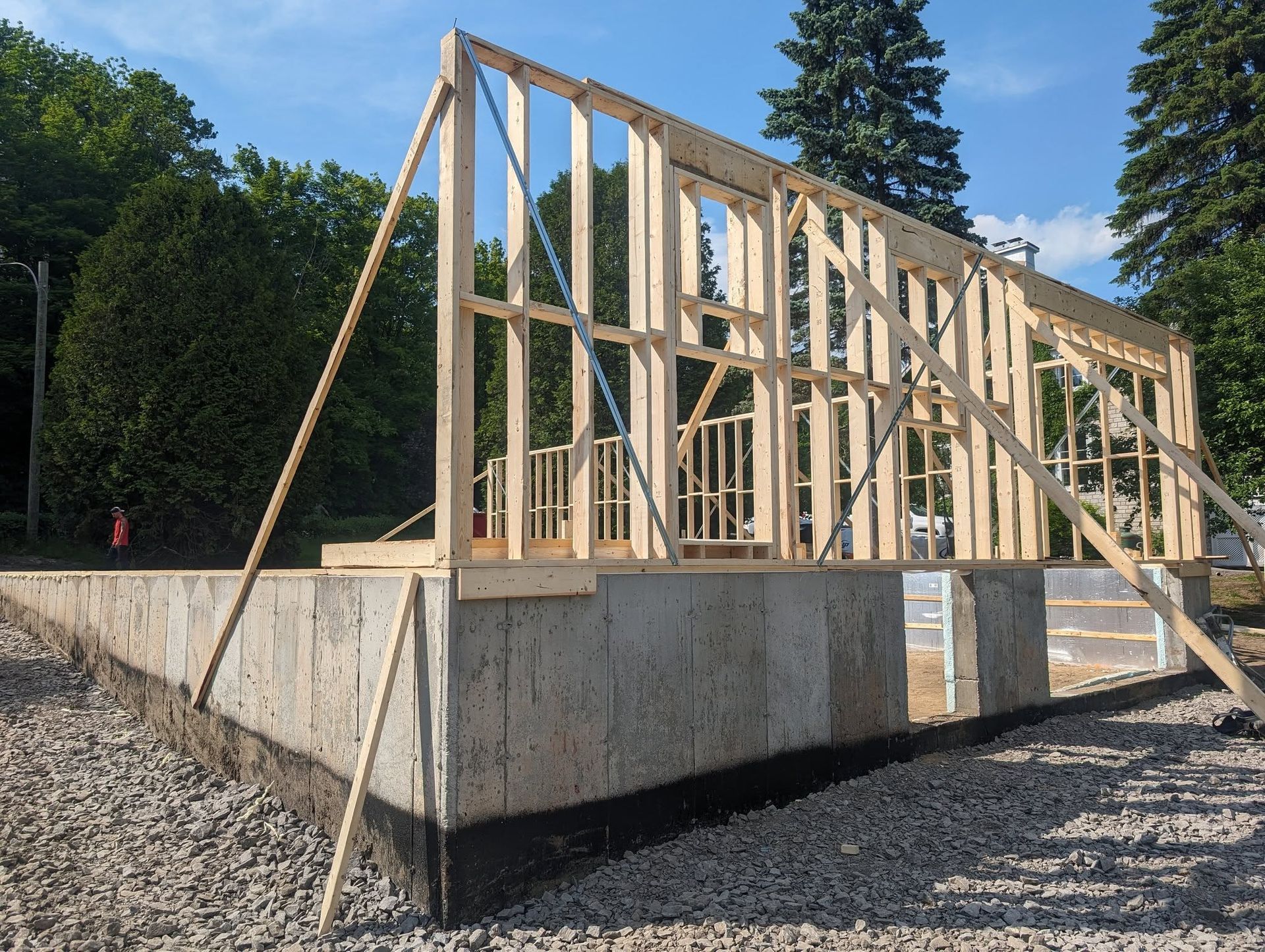 Une grande structure en bois est en cours de construction dans une zone de gravier