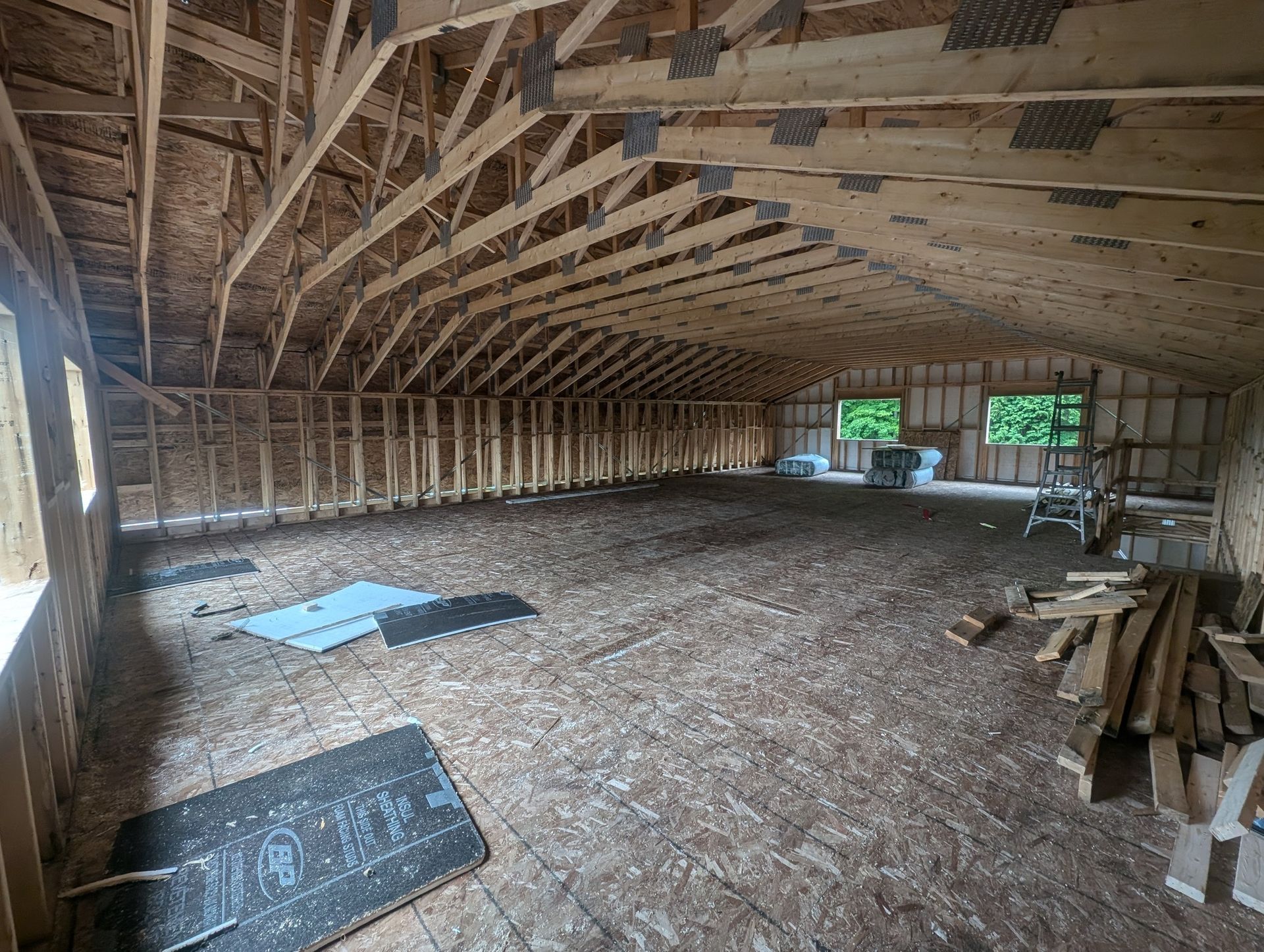 L'intérieur d'un bâtiment en construction avec beaucoup de poutres en bois.