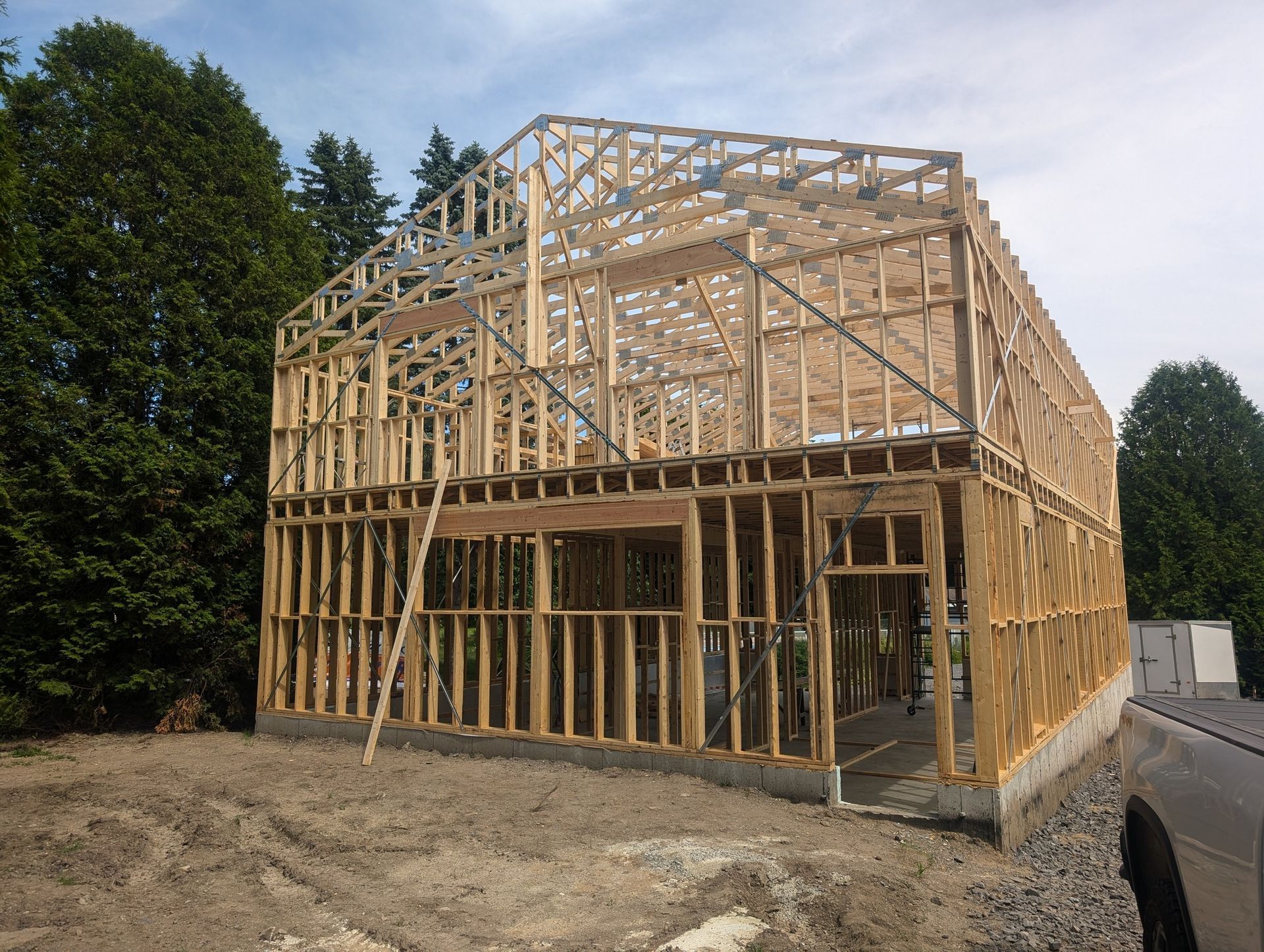 Une grande structure en bois est en cours de construction avec un camion garé devant elle