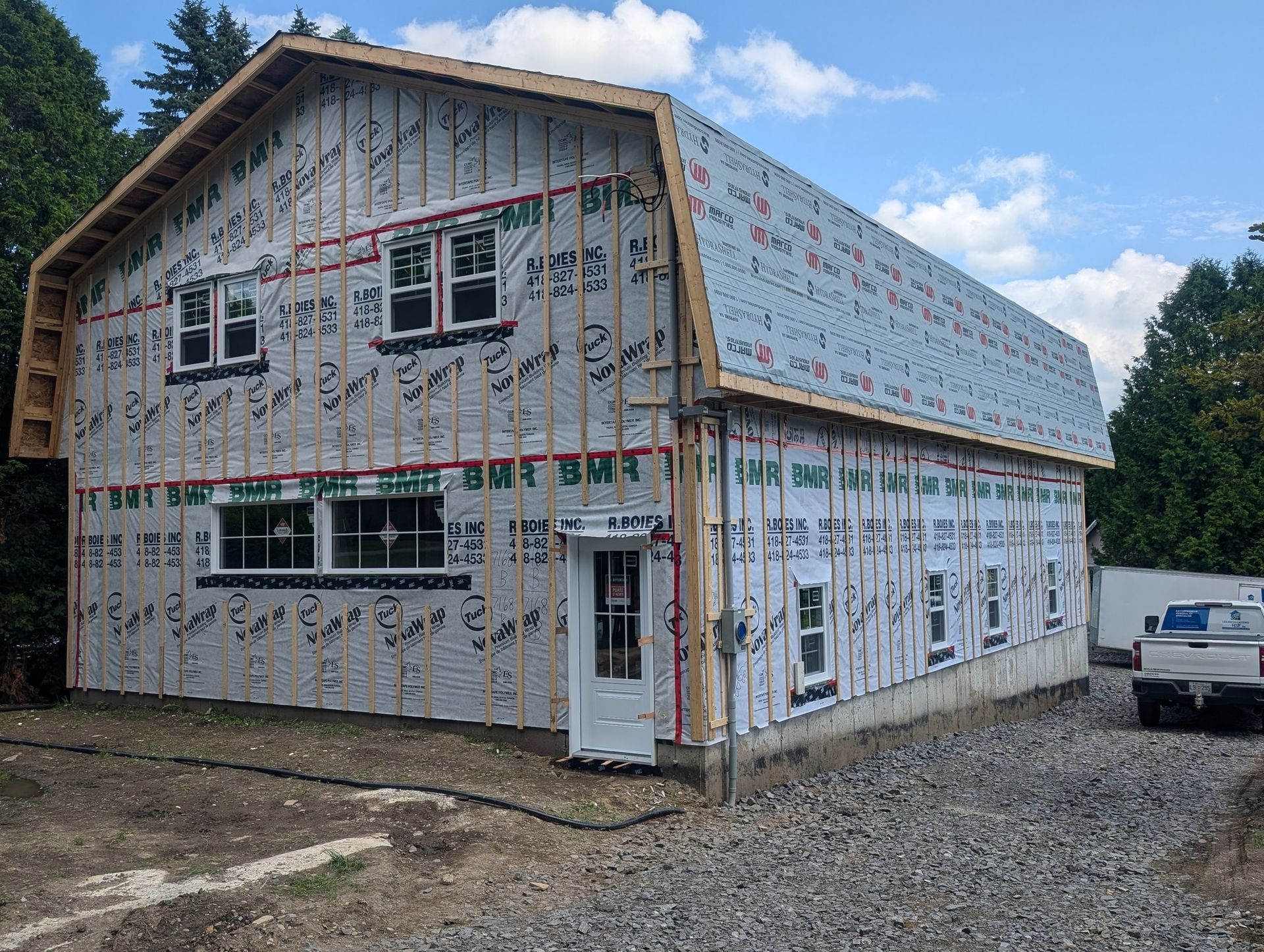 Un grand bâtiment est en construction avec un camion garé devant.