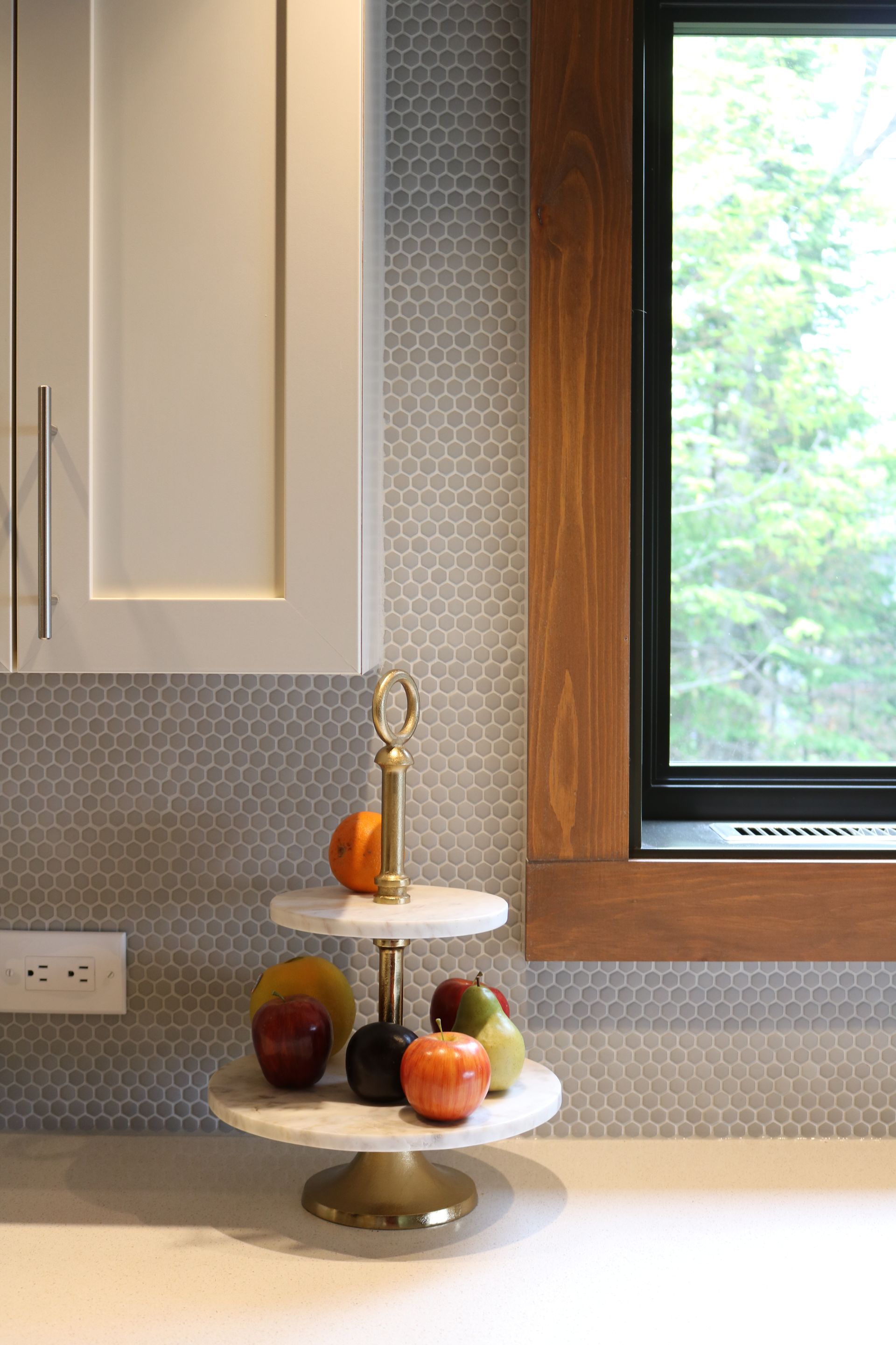 Un comptoir de cuisine avec un étal de fruits et une fenêtre.