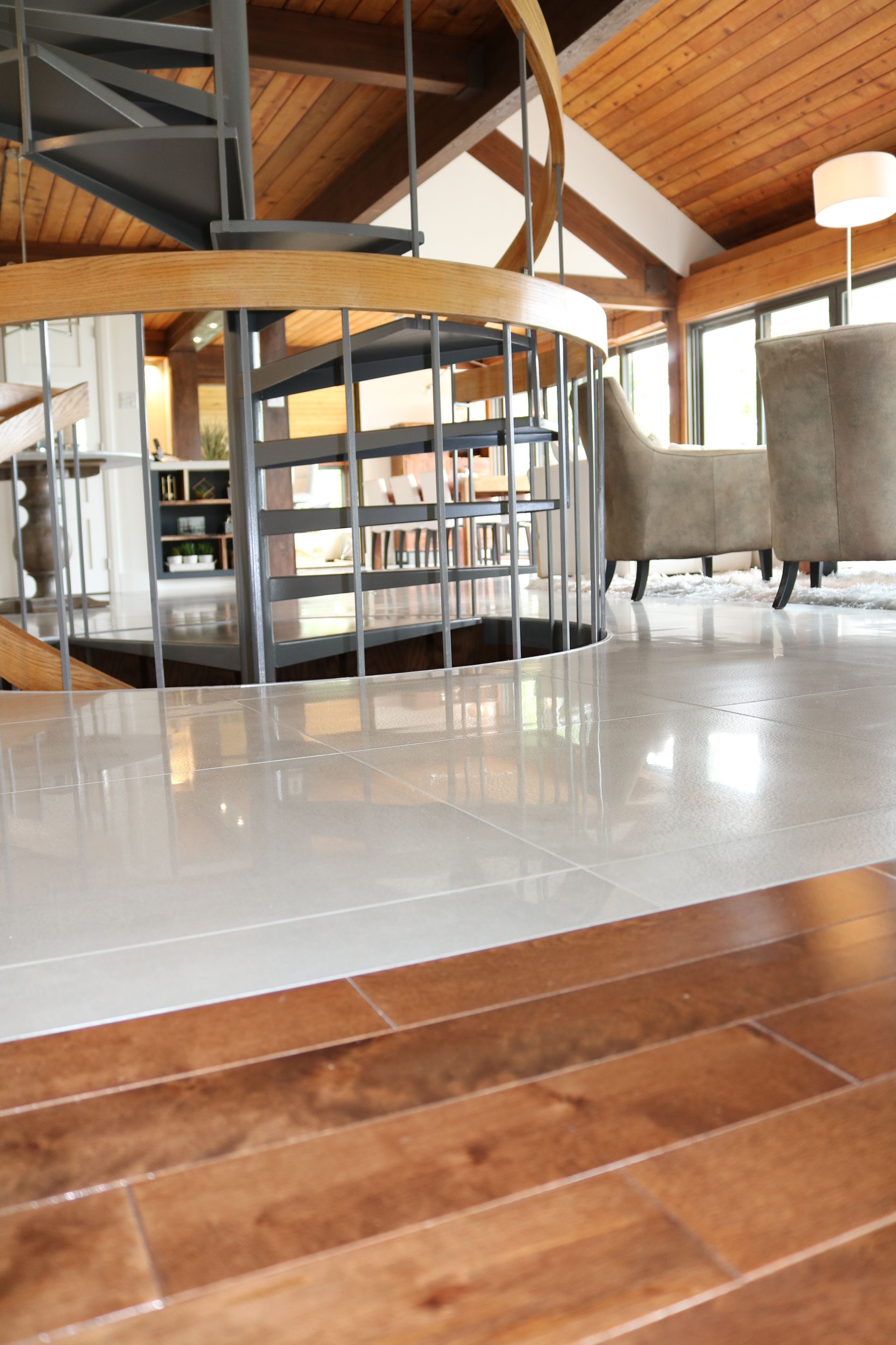 Un salon avec un escalier en colimaçon et une rampe en bois