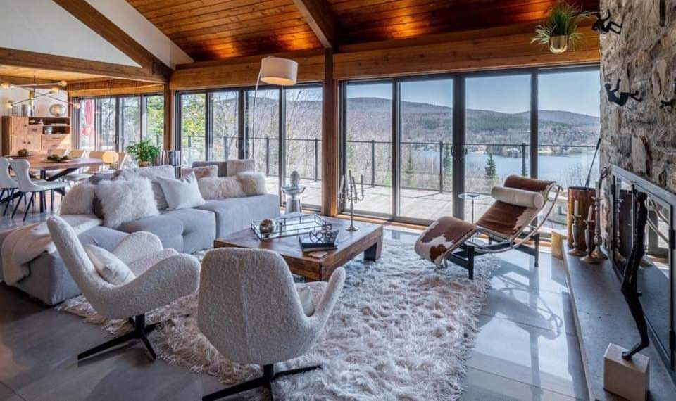 Un salon rempli de meubles et d'une cheminée avec vue sur un lac.