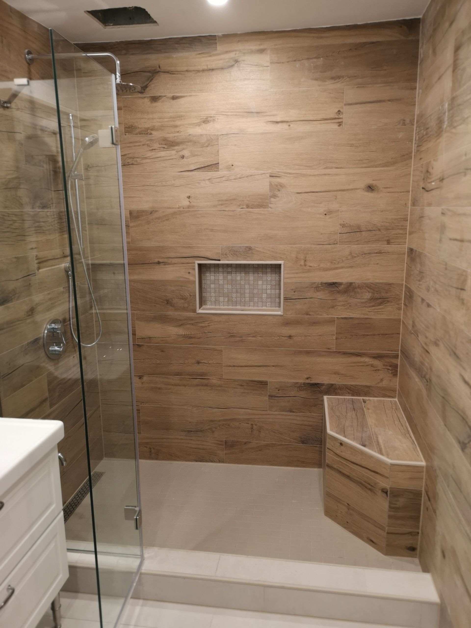 Une salle de bain avec des murs en bois et une douche à l'italienne