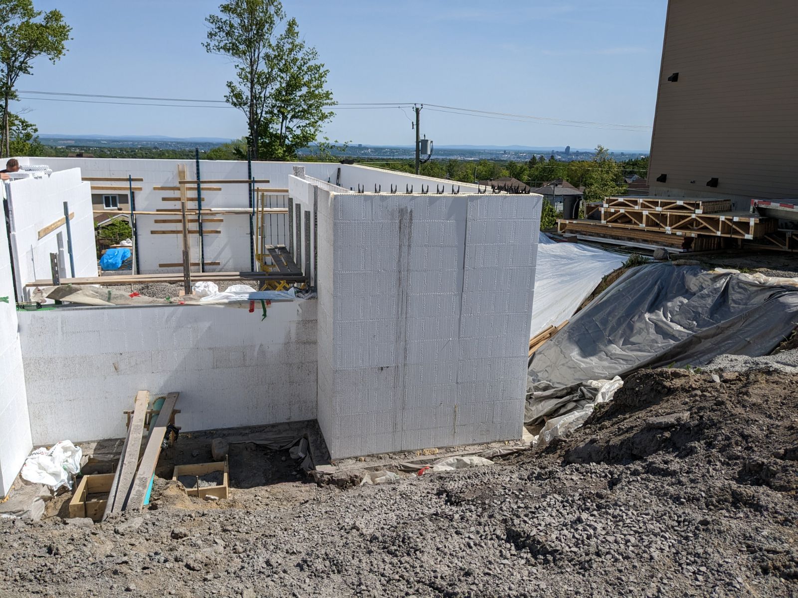 Un bâtiment est en cours de construction au sommet d'une colline de terre.