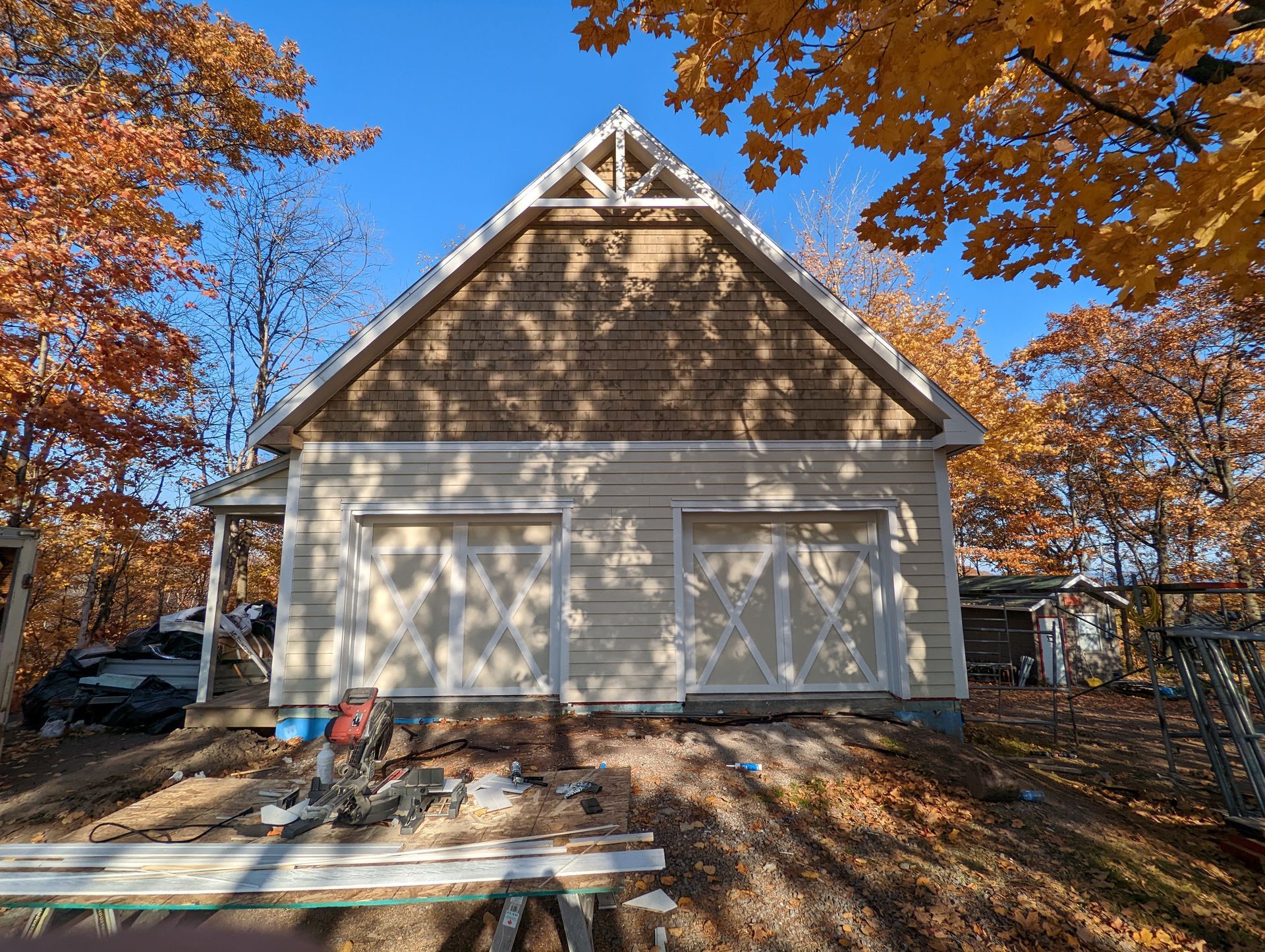 Une maison blanche avec un toit qui est en construction dans les bois.