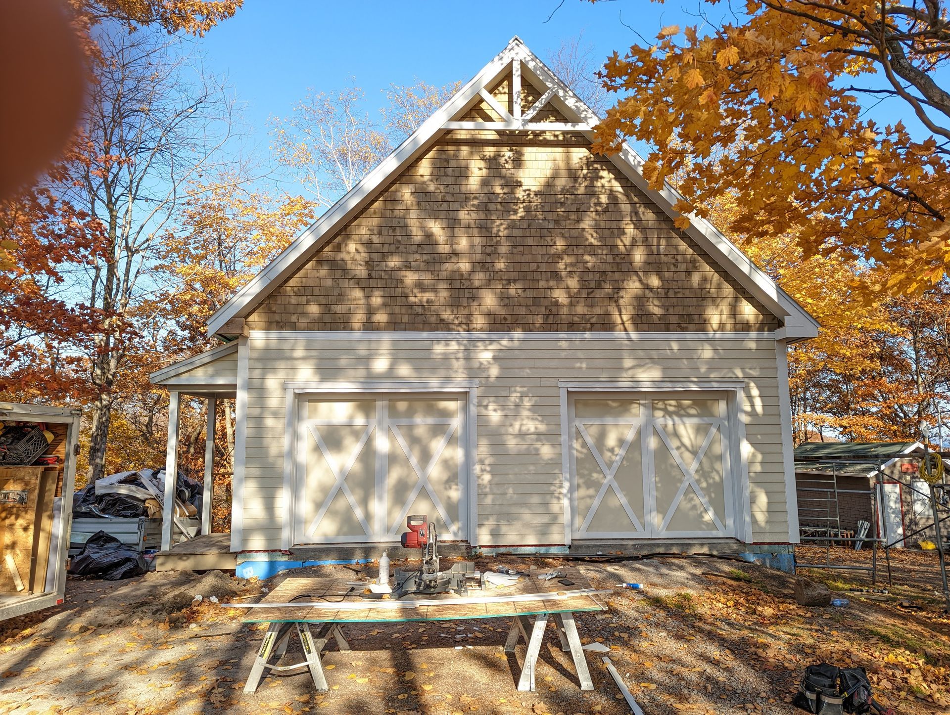 Un garage est en cours de construction dans les bois avec une table de pique-nique devant.