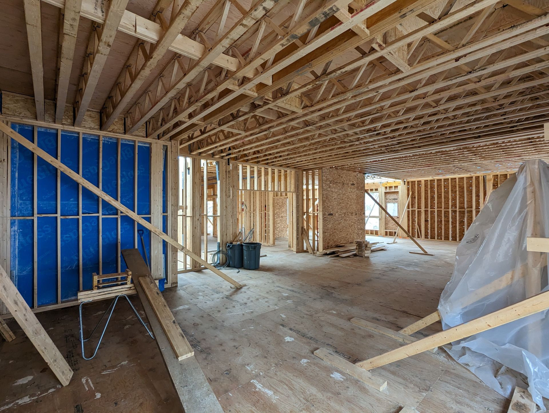 L'intérieur d'une maison en construction avec des poutres en bois.