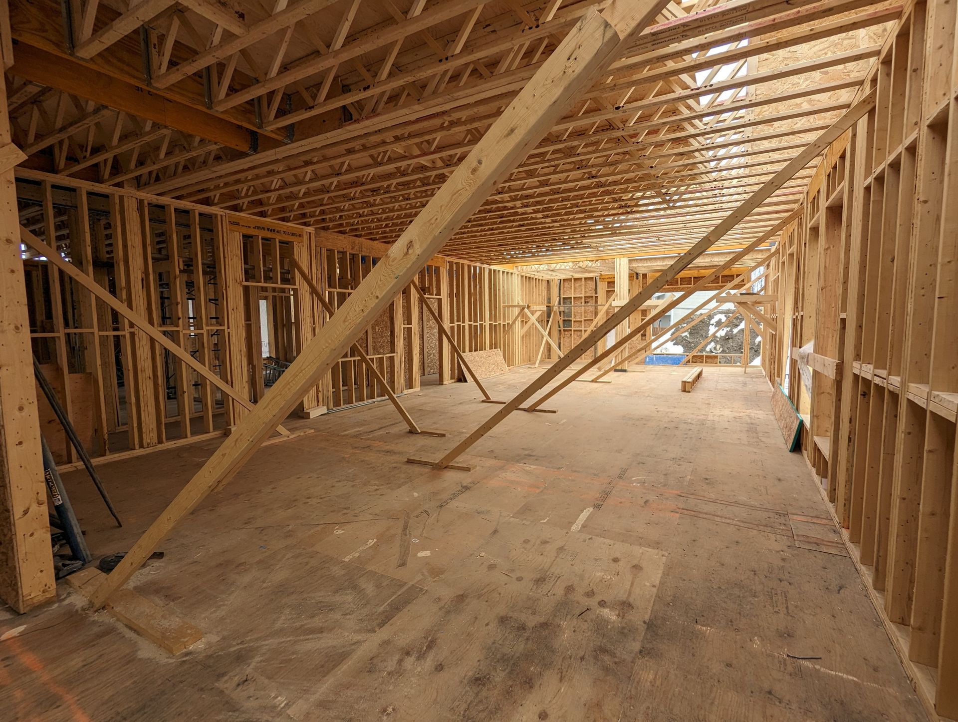 Une grande pièce en construction avec beaucoup de poutres en bois.