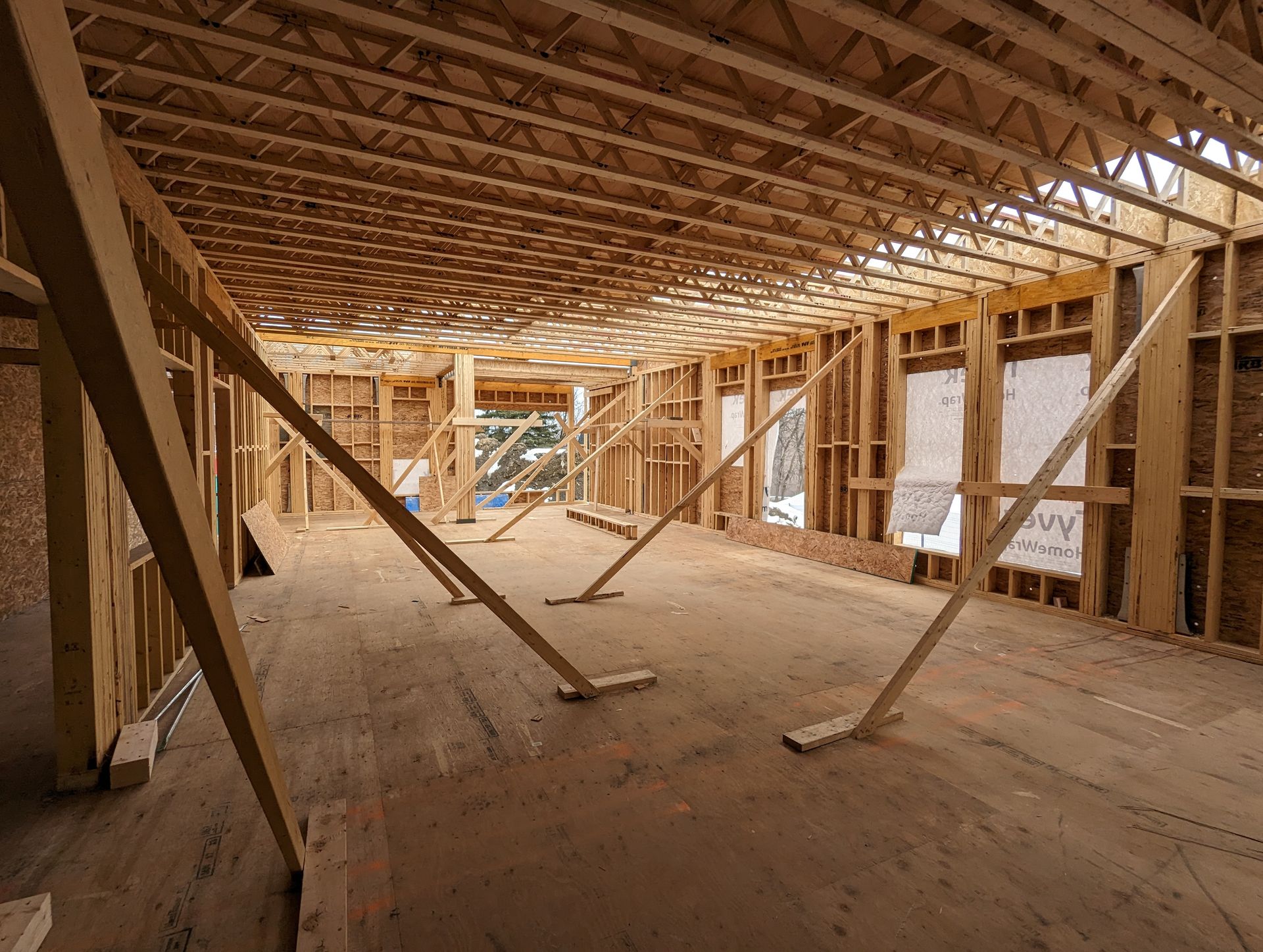 L'intérieur d'un bâtiment en construction avec beaucoup de poutres en bois.