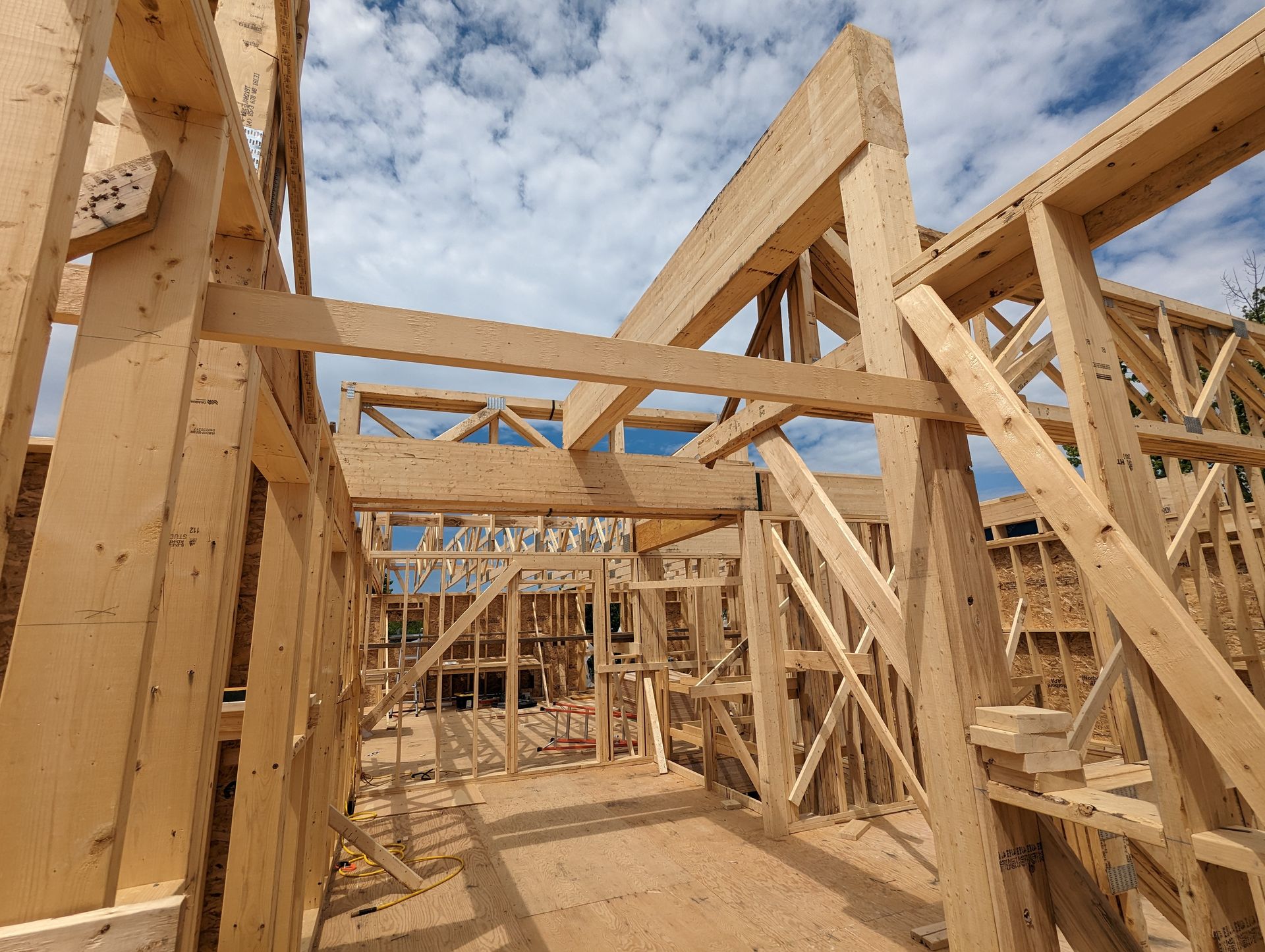 Une structure en bois est en cours de construction avec un ciel bleu en arrière-plan