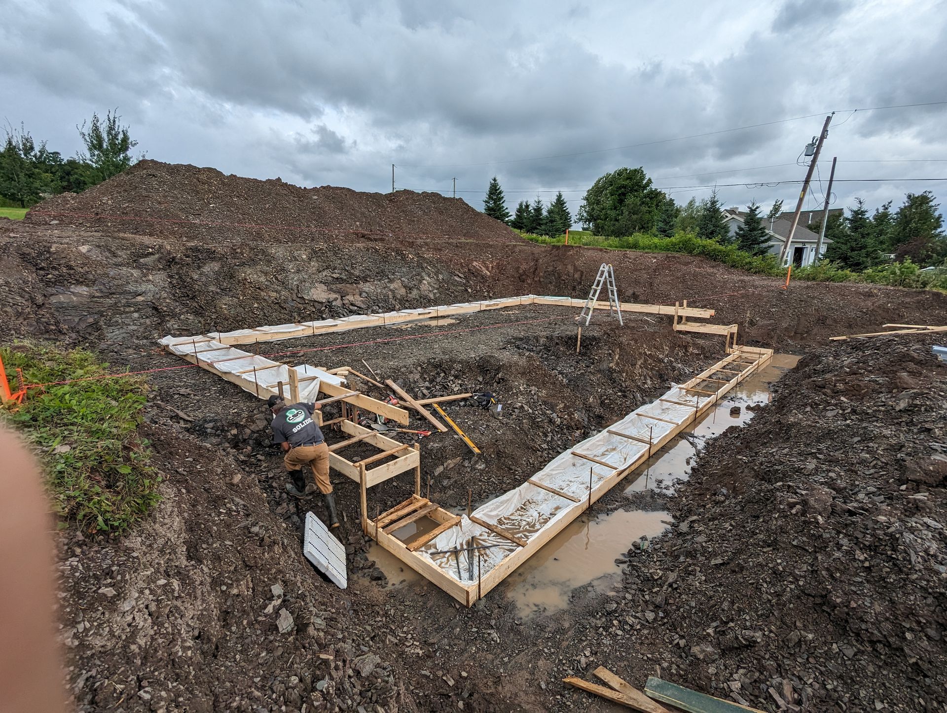 Un chantier de construction avec un gros tas de terre en arrière-plan.