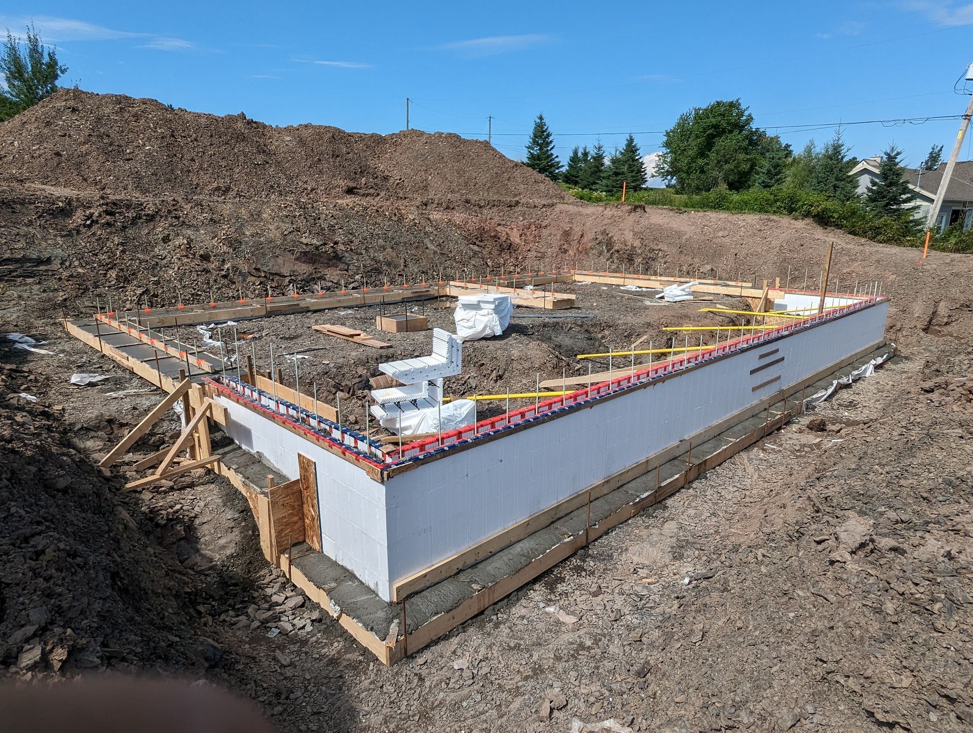 Les fondations d'une maison sont en train d'être construites dans un champ de terre.