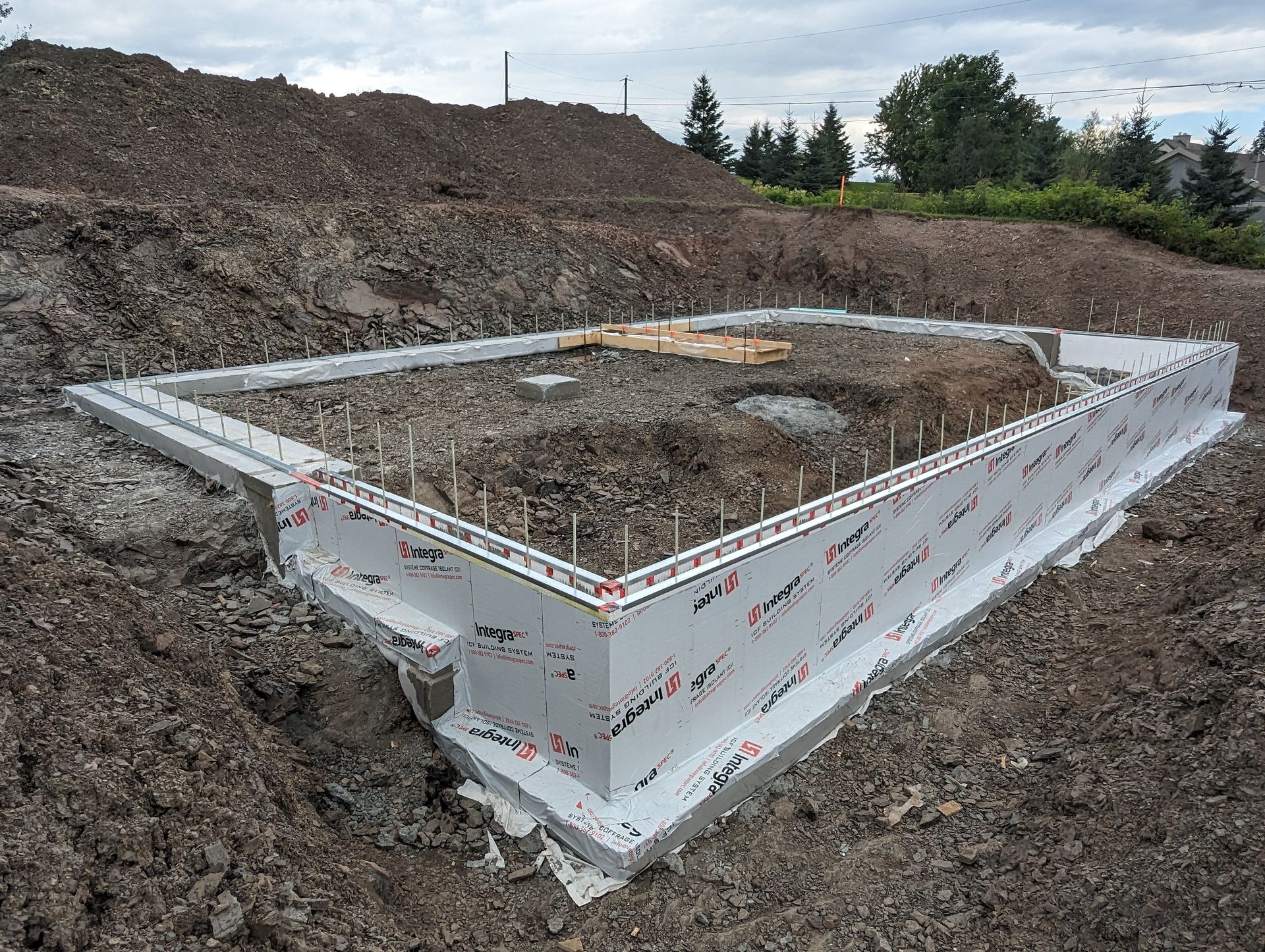 Les fondations d'une maison sont en train d'être construites dans la terre.