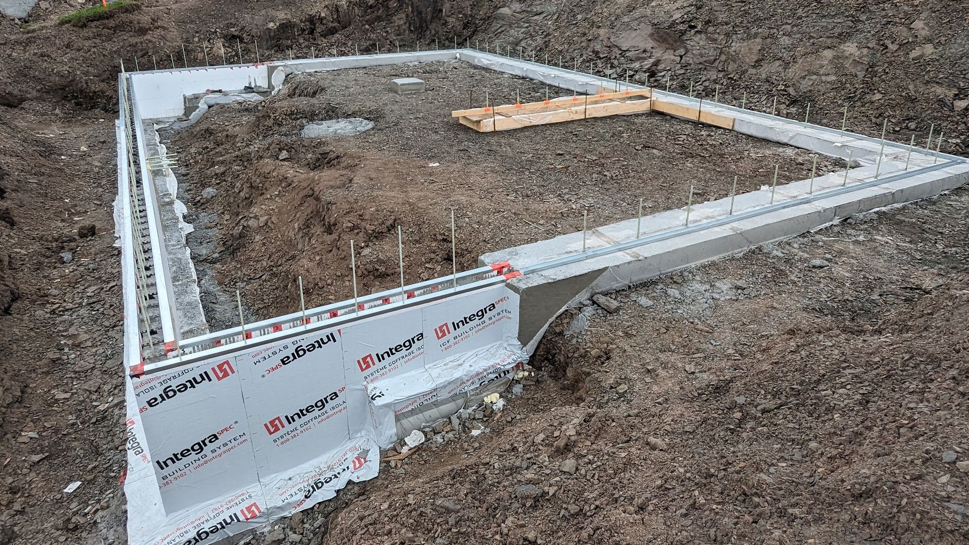 Une fondation en béton est en train d'être construite dans la terre.
