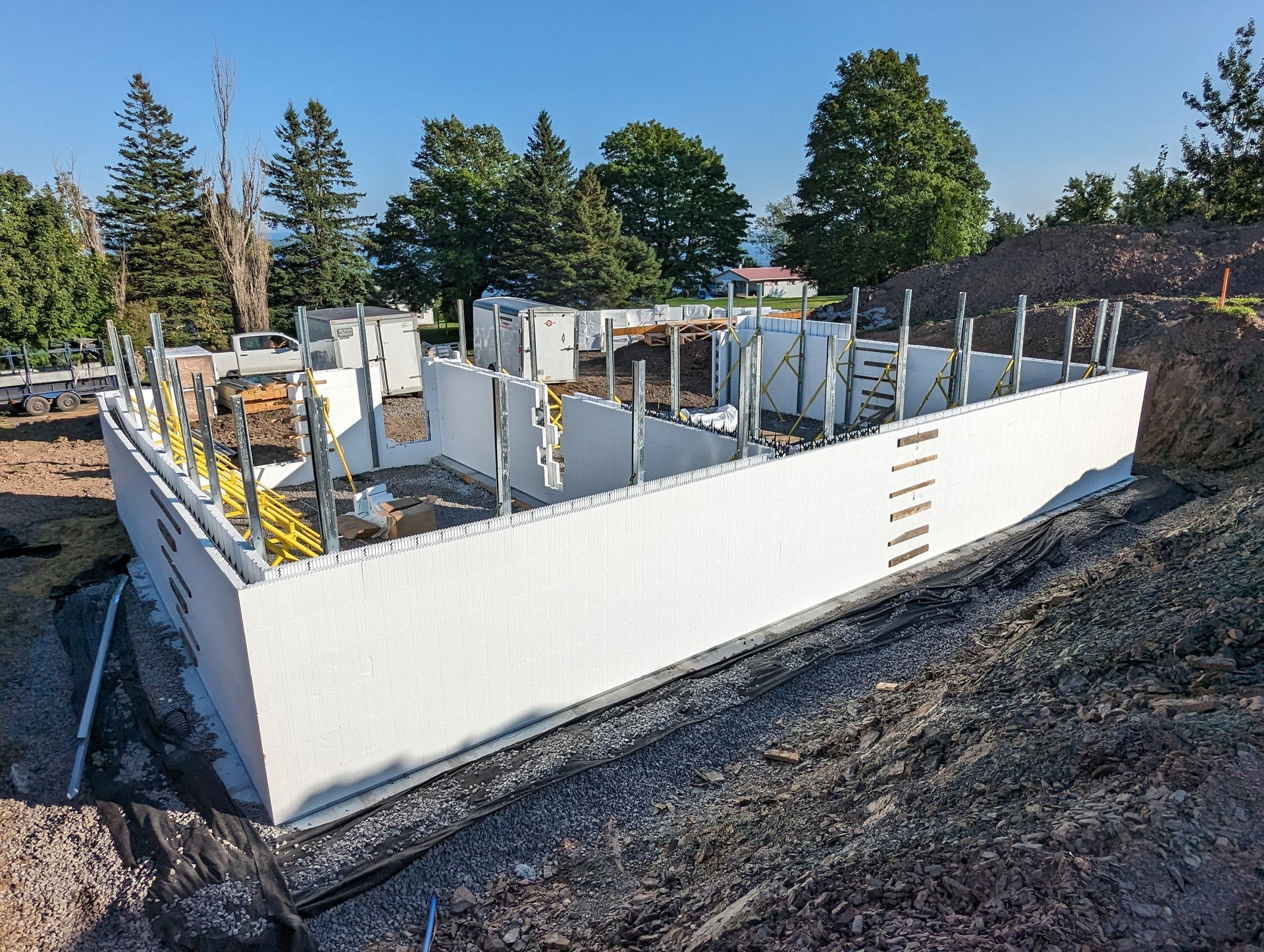 Un grand mur blanc se trouve au sommet d'un champ de terre.