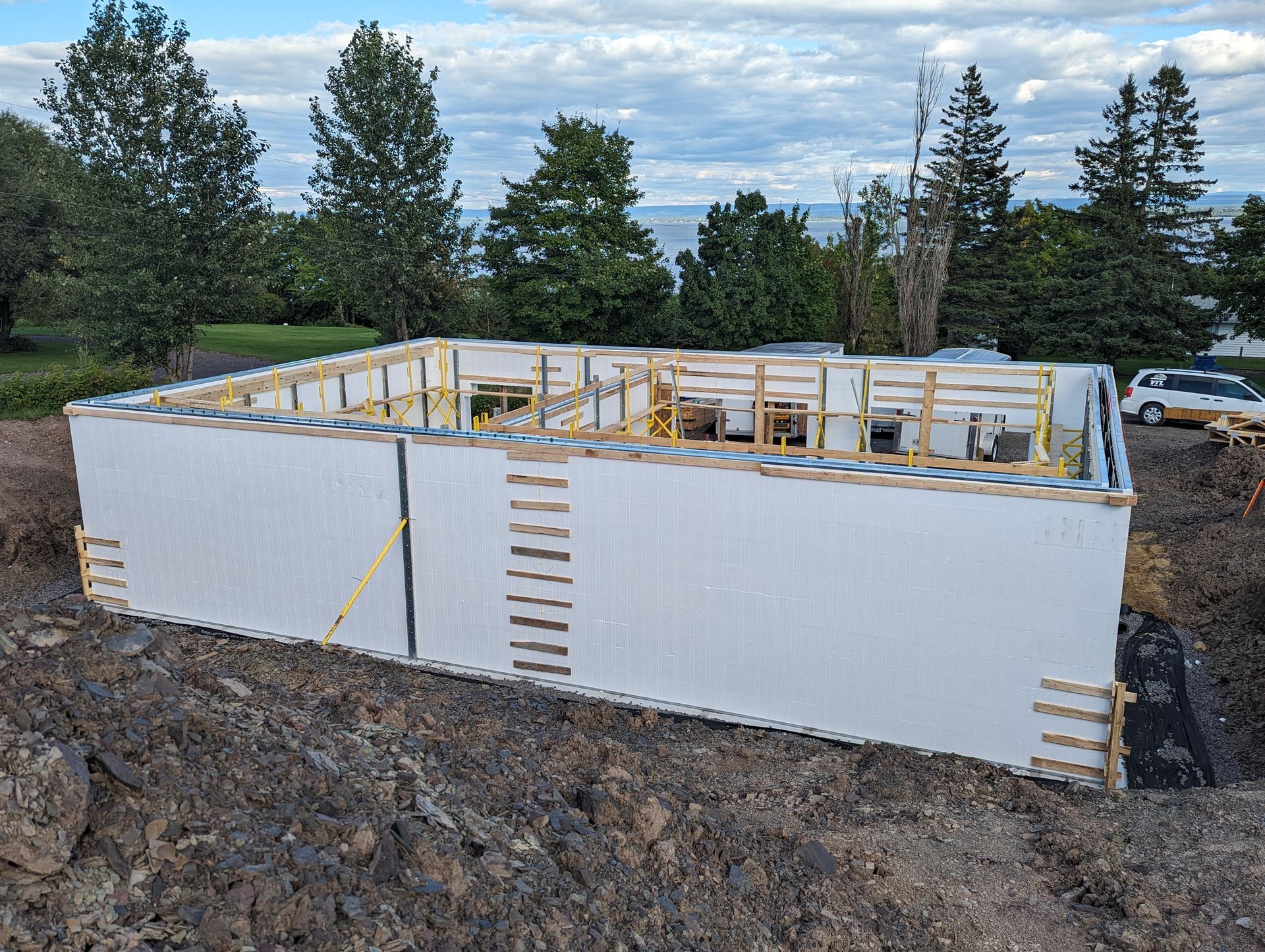Une grande boîte blanche se trouve au milieu d'un champ de terre.
