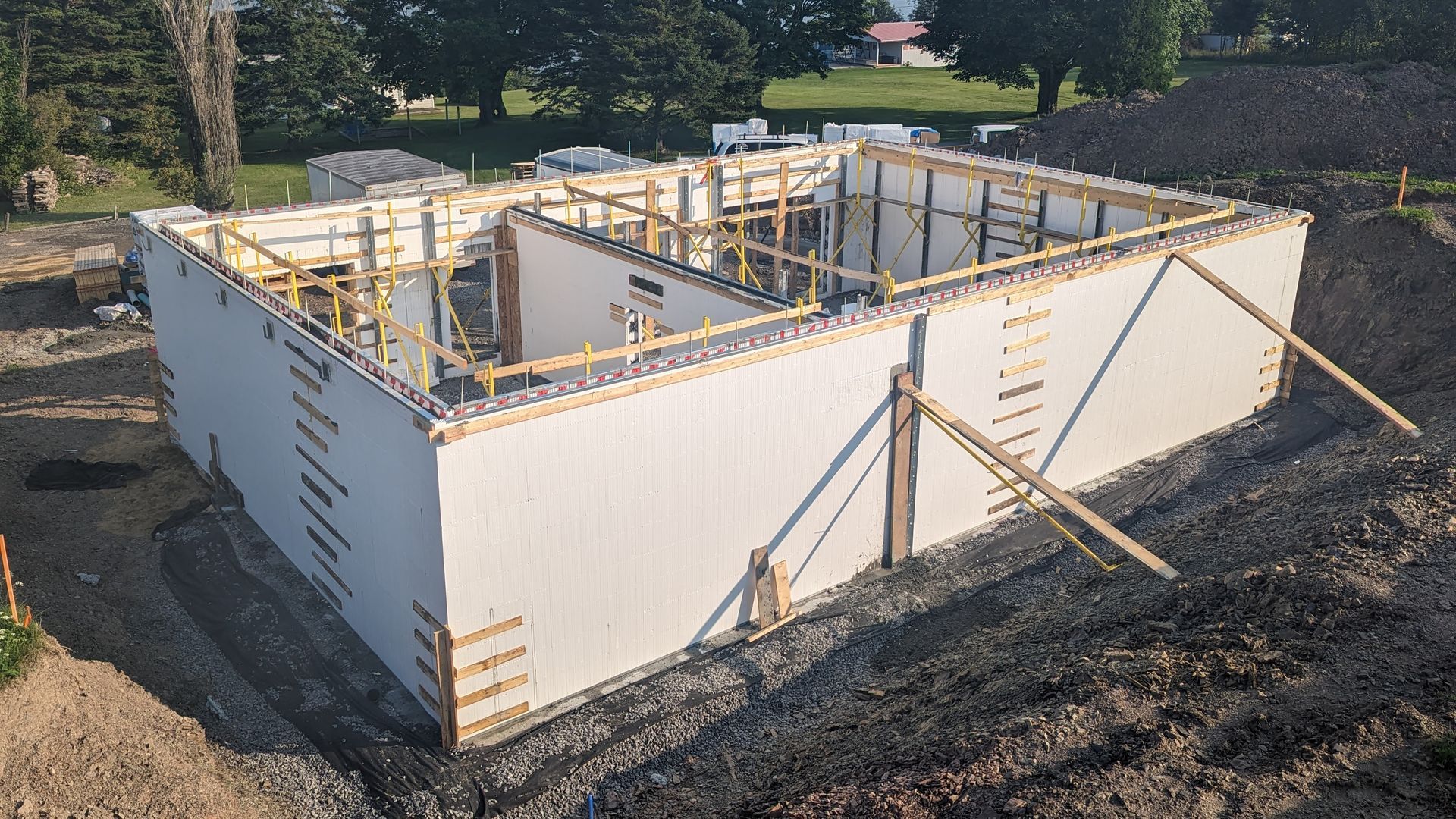 Un grand bâtiment est en cours de construction au sommet d'une colline de terre.