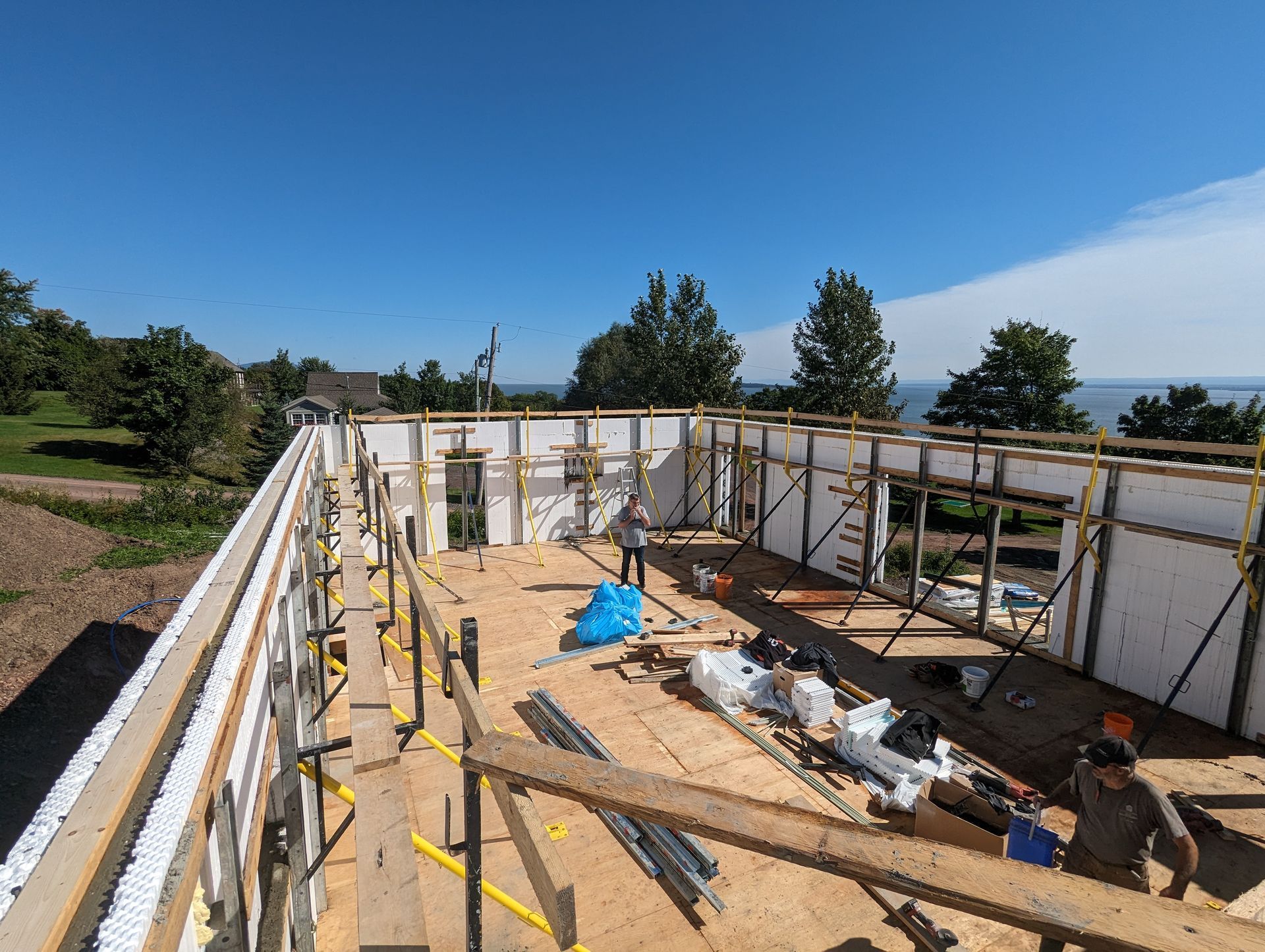 Un homme se tient sur le toit d'un immeuble en construction.