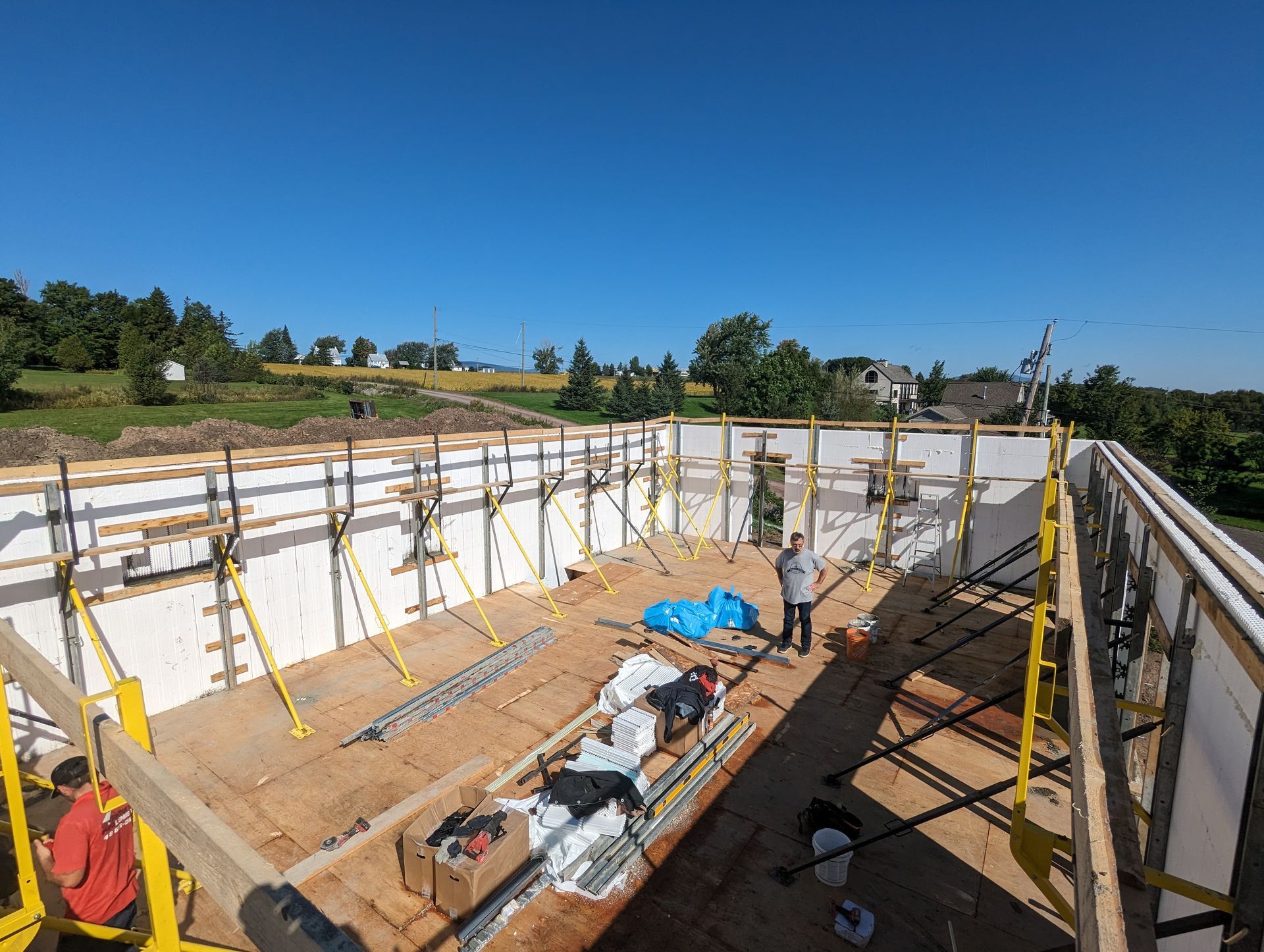 Un homme se tient sur le toit d'un immeuble en construction.