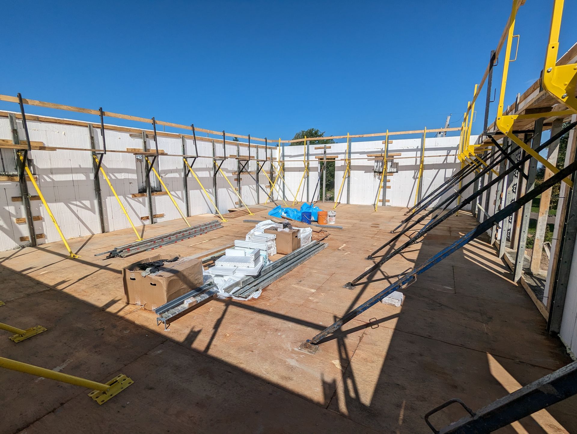 Un chantier avec beaucoup d'échafaudages et de caisses au sol.