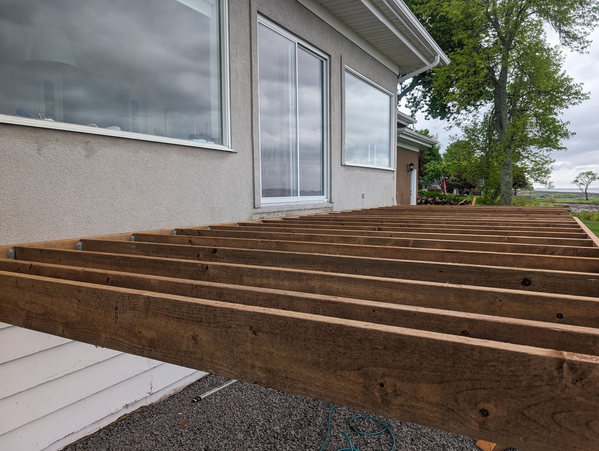 Une terrasse en bois est en cours de construction devant une maison.