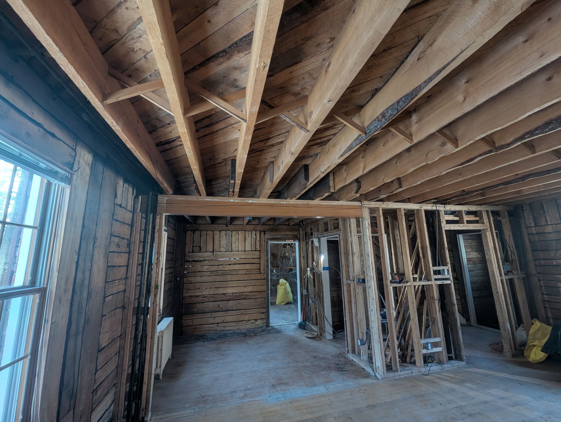 Une pièce avec beaucoup de poutres en bois suspendues au plafond