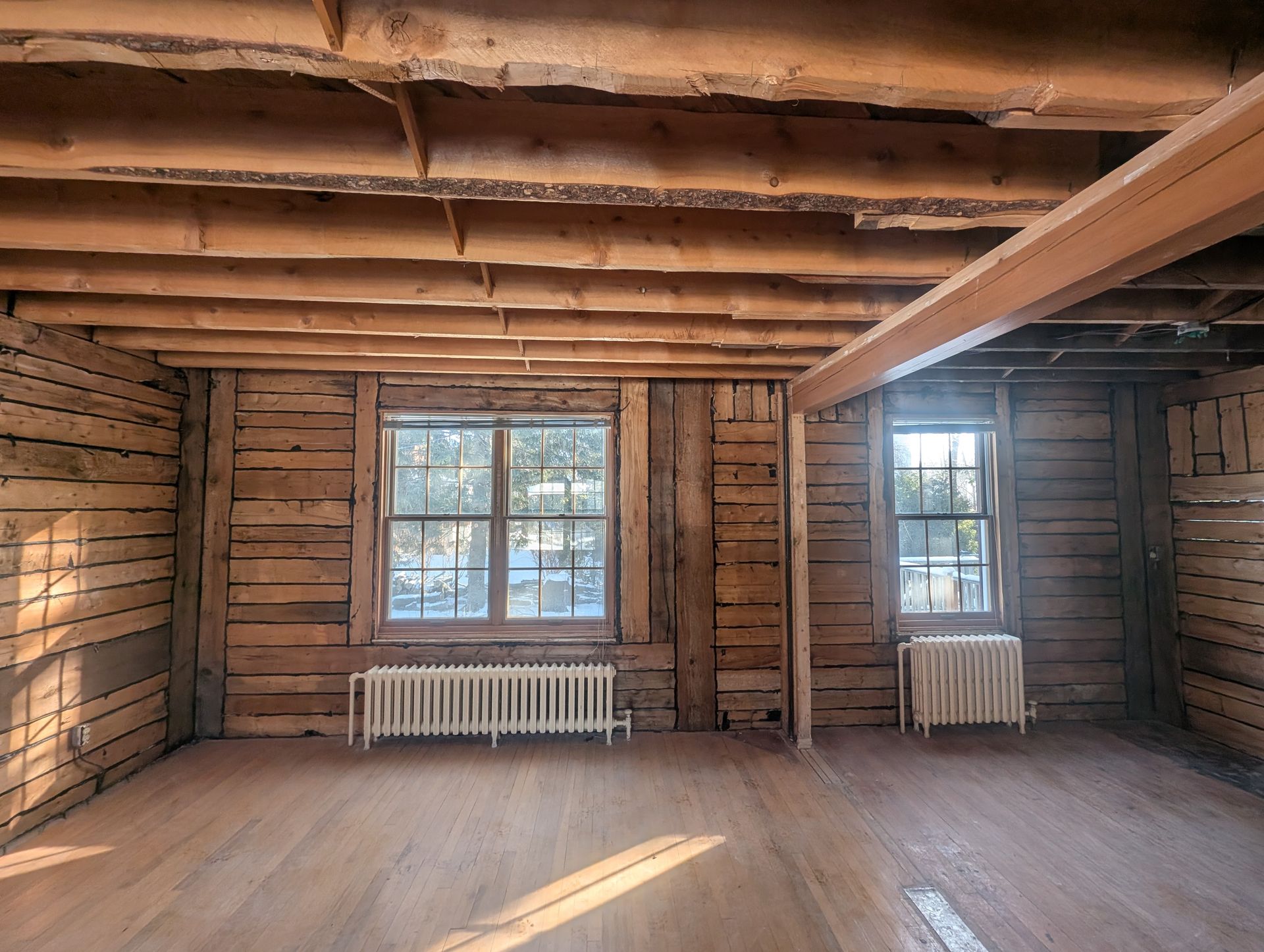 Une pièce vide avec des murs en bois et un radiateur.