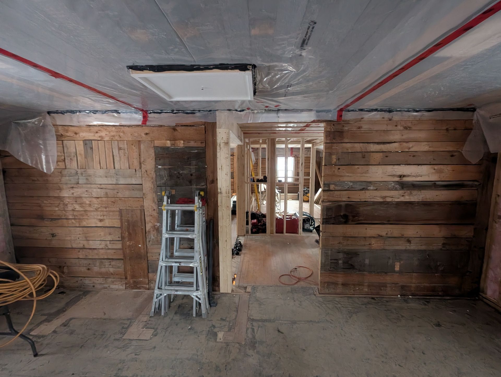 Une pièce avec des murs en bois et une échelle au sol