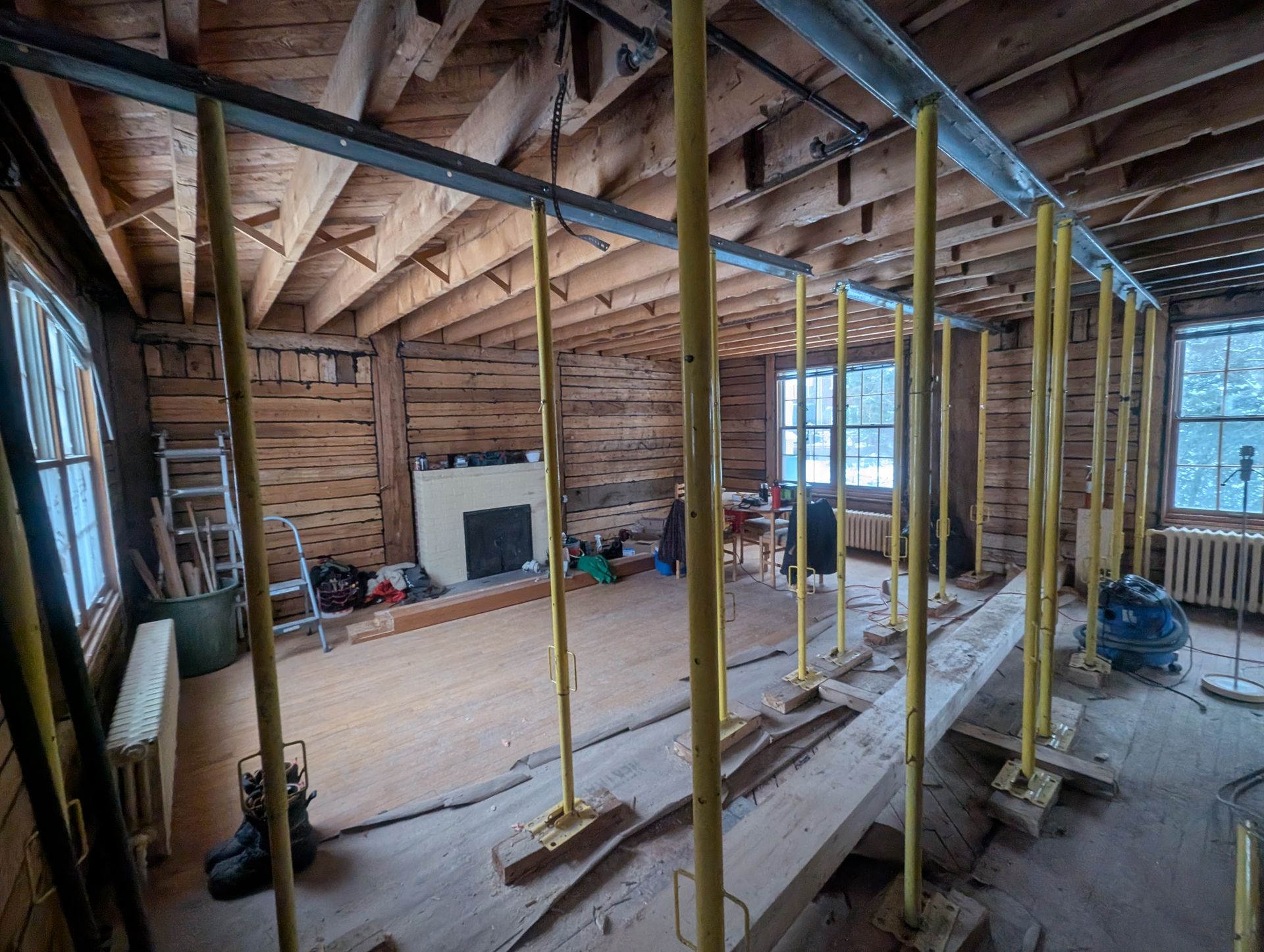 Une pièce en construction avec une cheminée et une échelle.