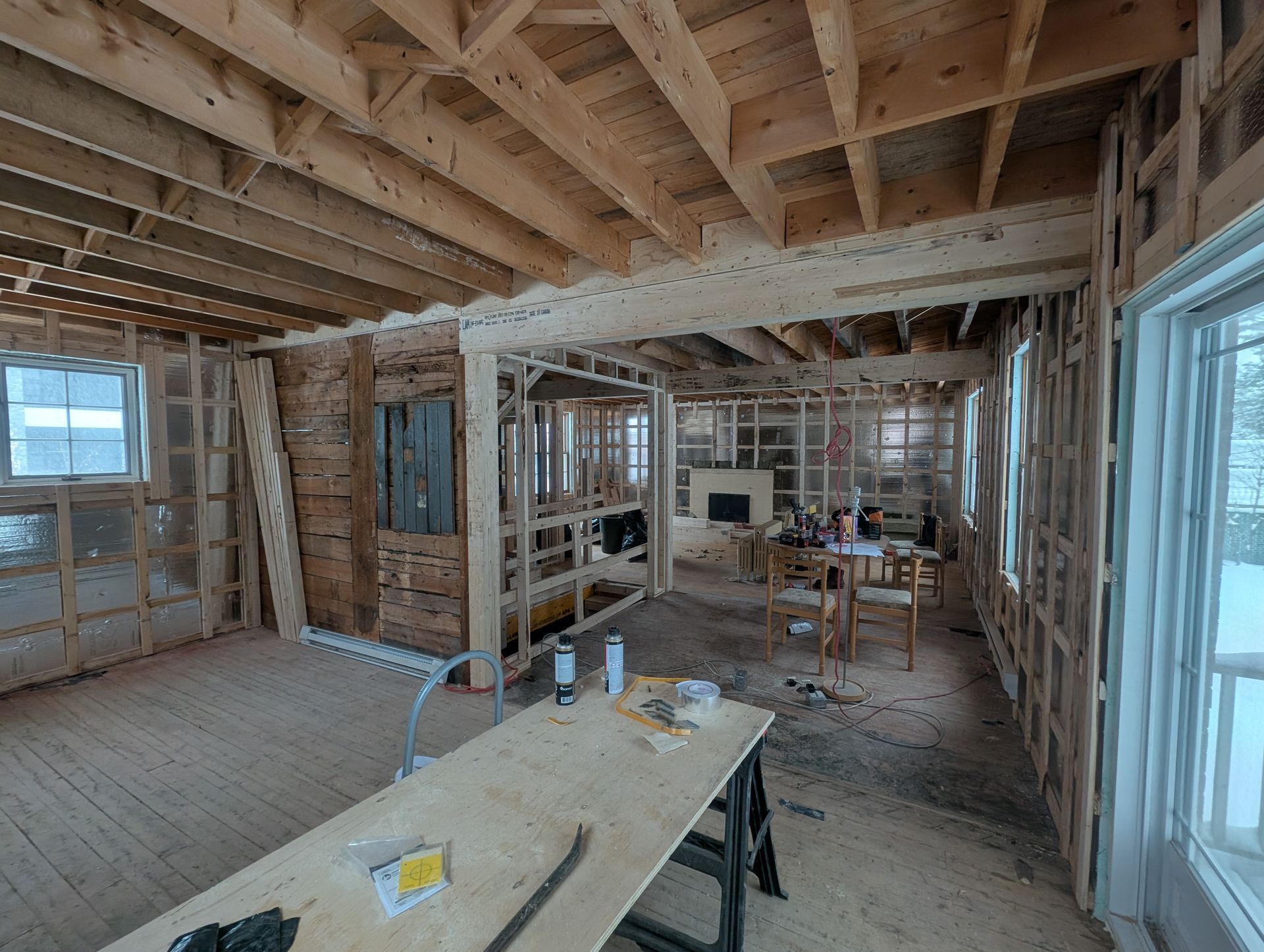 Une grande pièce avec une table en bois au milieu.