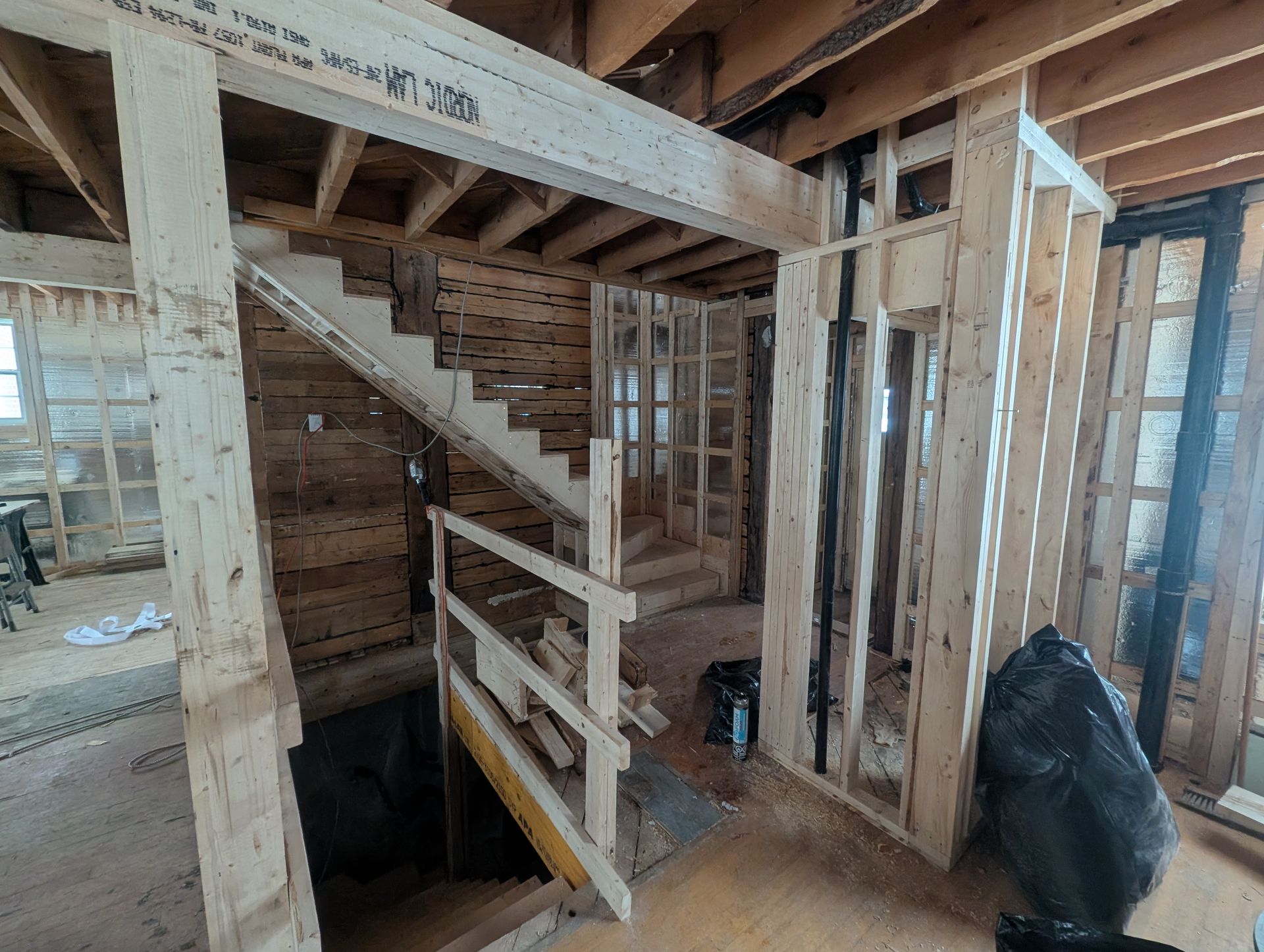 Un escalier en bois est en cours de construction dans une maison en construction.