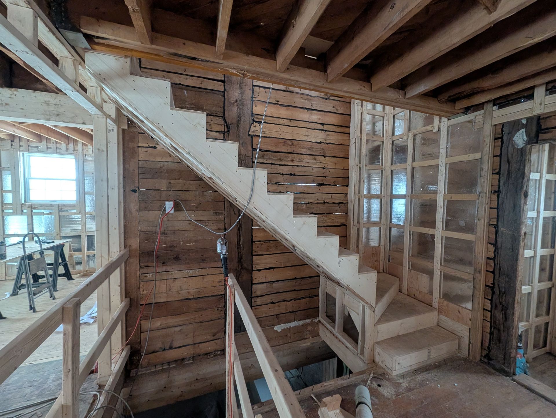 Un escalier en bois est en cours de construction dans une maison en construction.