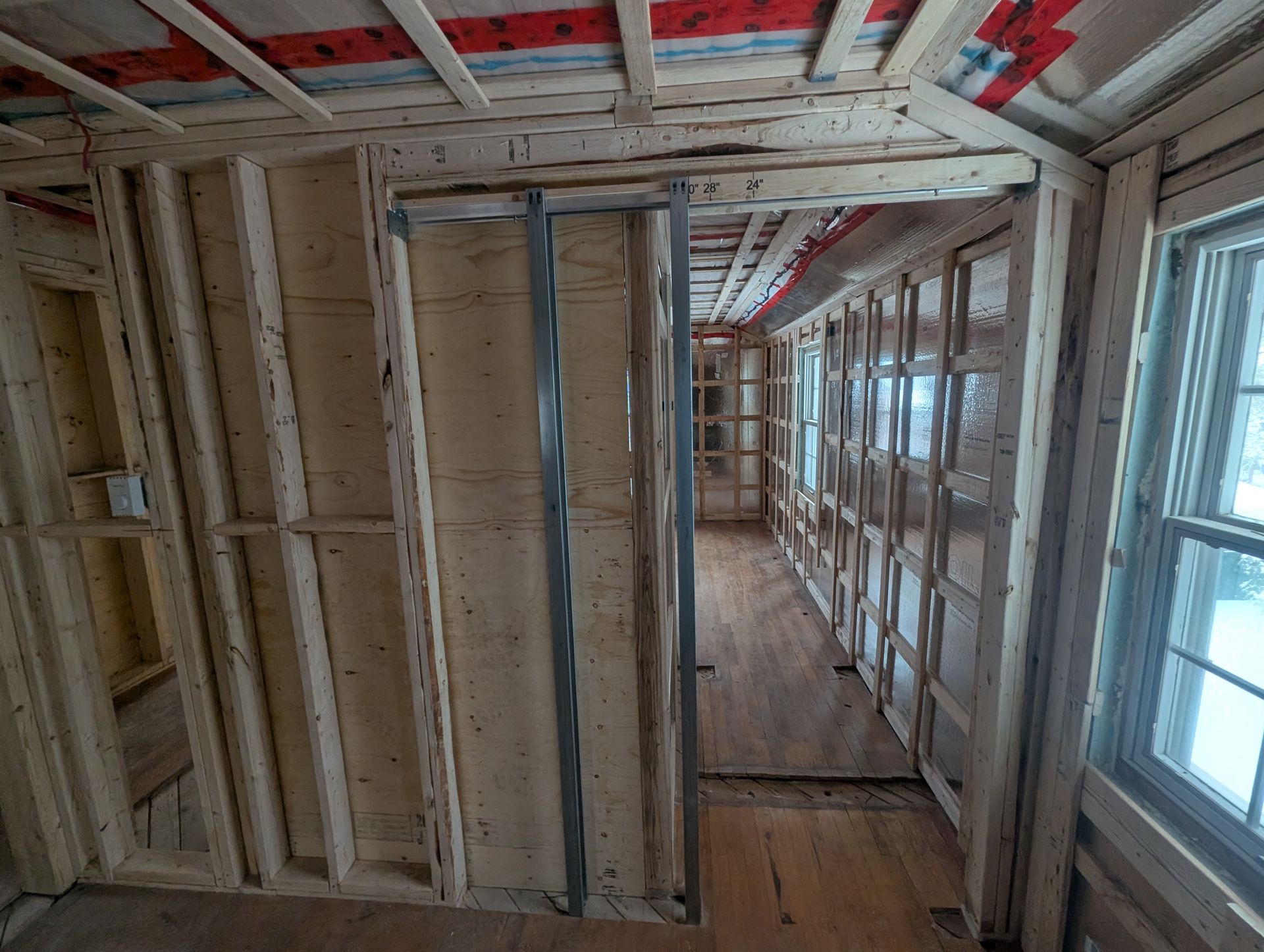 Un long couloir avec beaucoup de fenêtres et des murs en bois