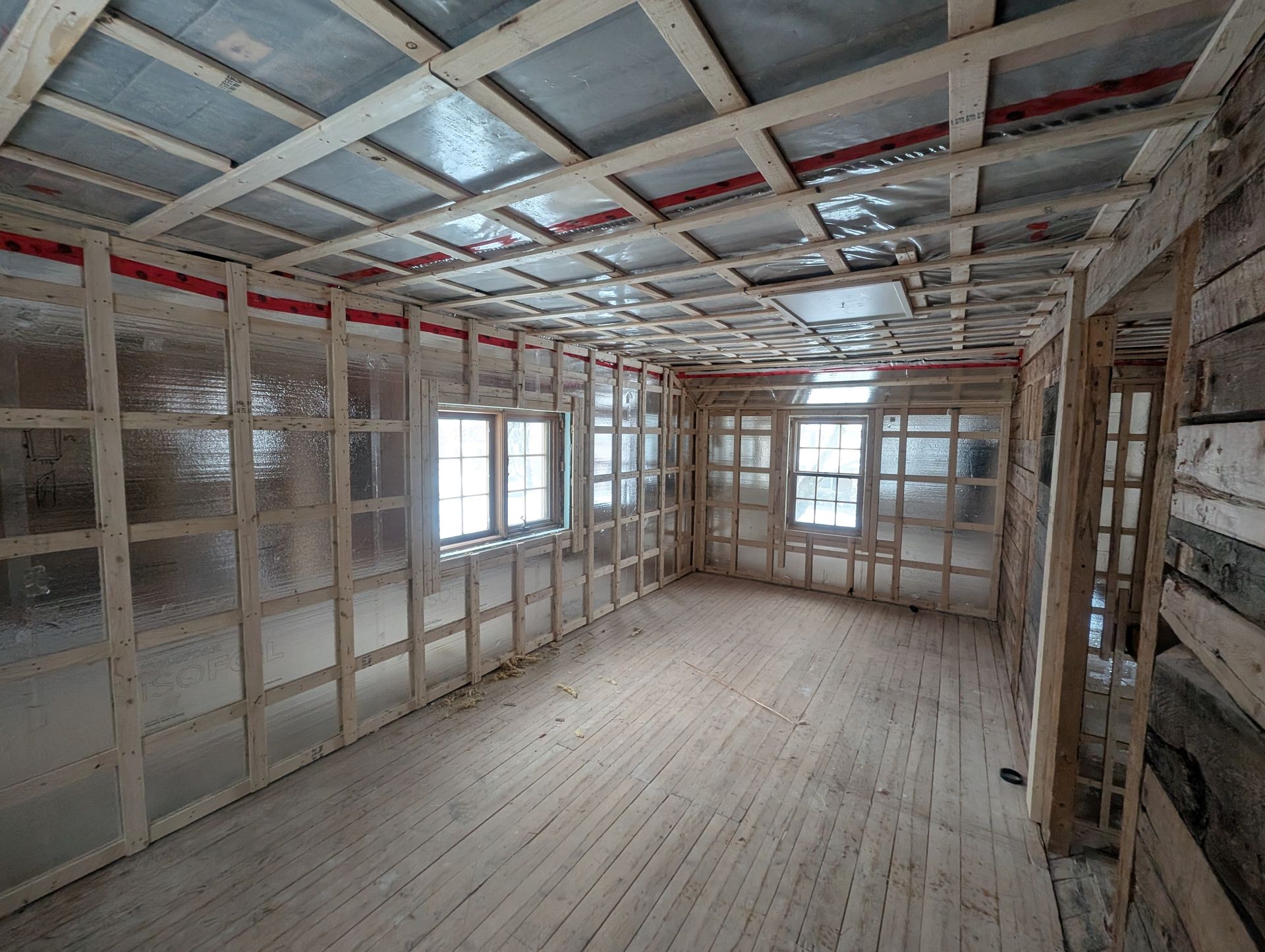 Une pièce vide avec des murs en bois et un plancher en bois en construction.