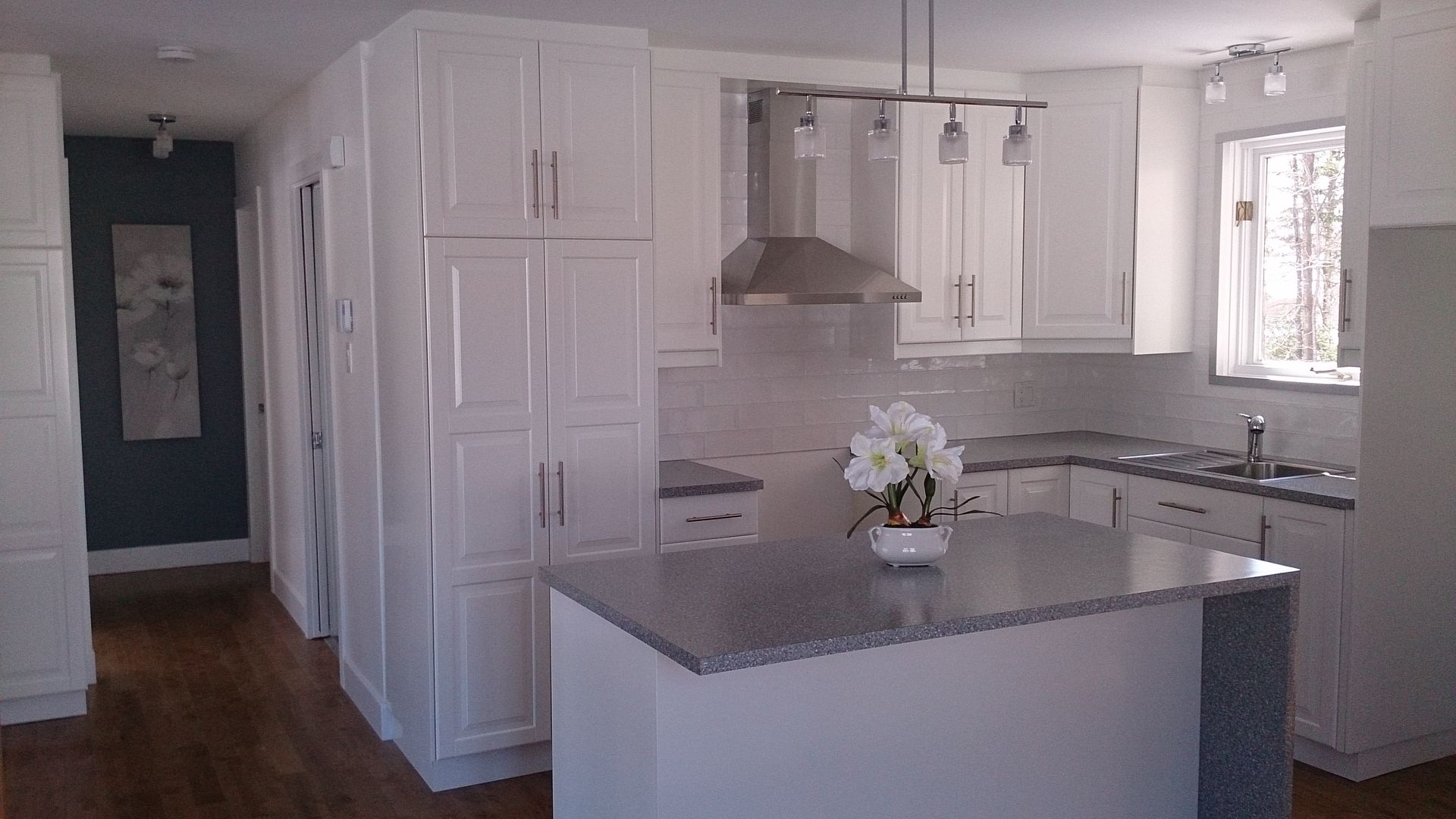 Une cuisine avec des armoires blanches et des comptoirs en granit