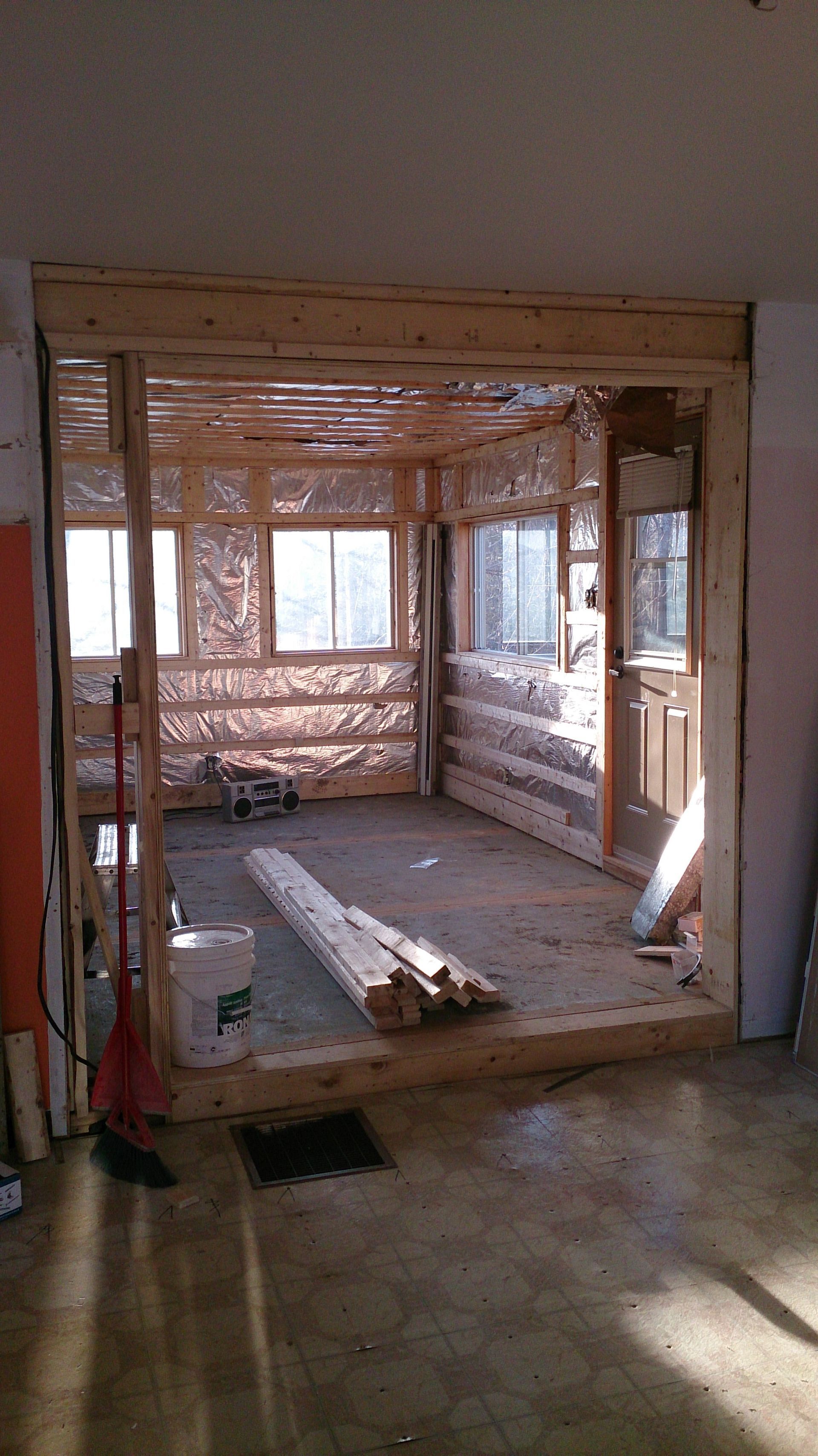 Une pièce avec un cadre en bois et un balai à l'intérieur.