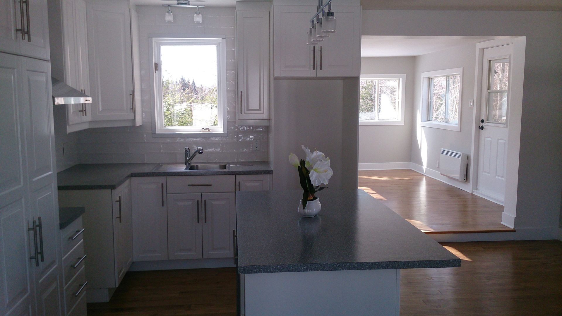 Une cuisine avec des armoires blanches et un comptoir en granit