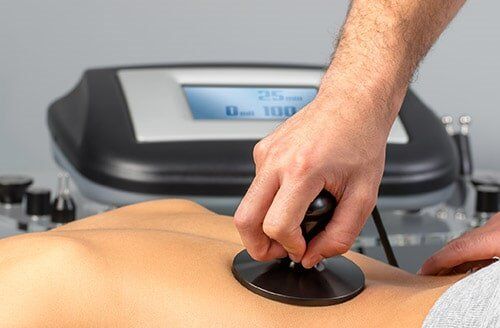 Applying Electrotherapy On Female Spine — Chiropractic in Maryville, TN