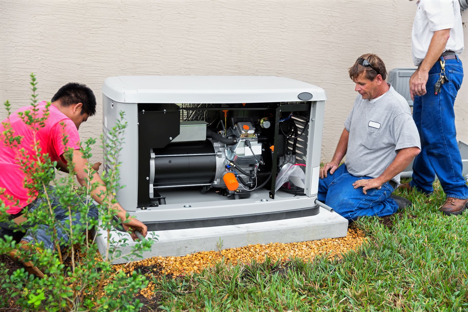 Two men are working on a generator outside of a building.