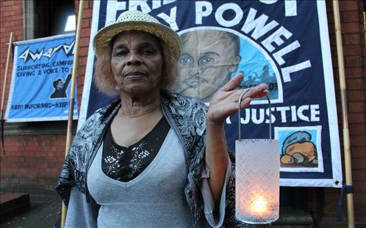 Mikey Powell's mother holds candle