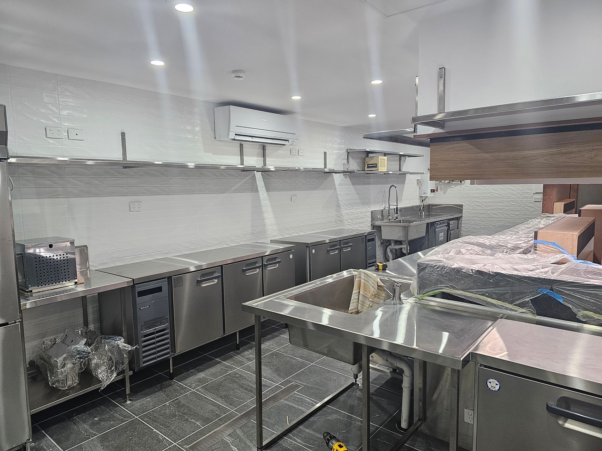 A kitchen with a stainless steel counter top and sink.