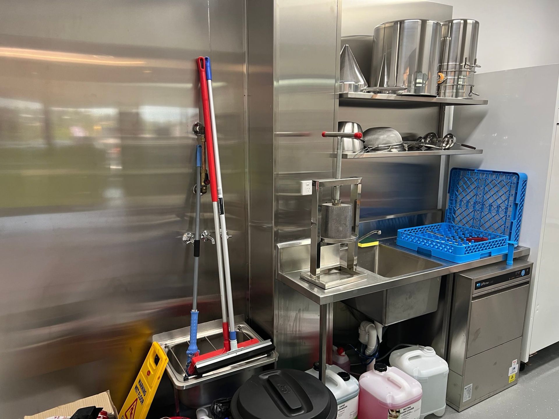A kitchen with a stainless steel sink and a bottle of soap
