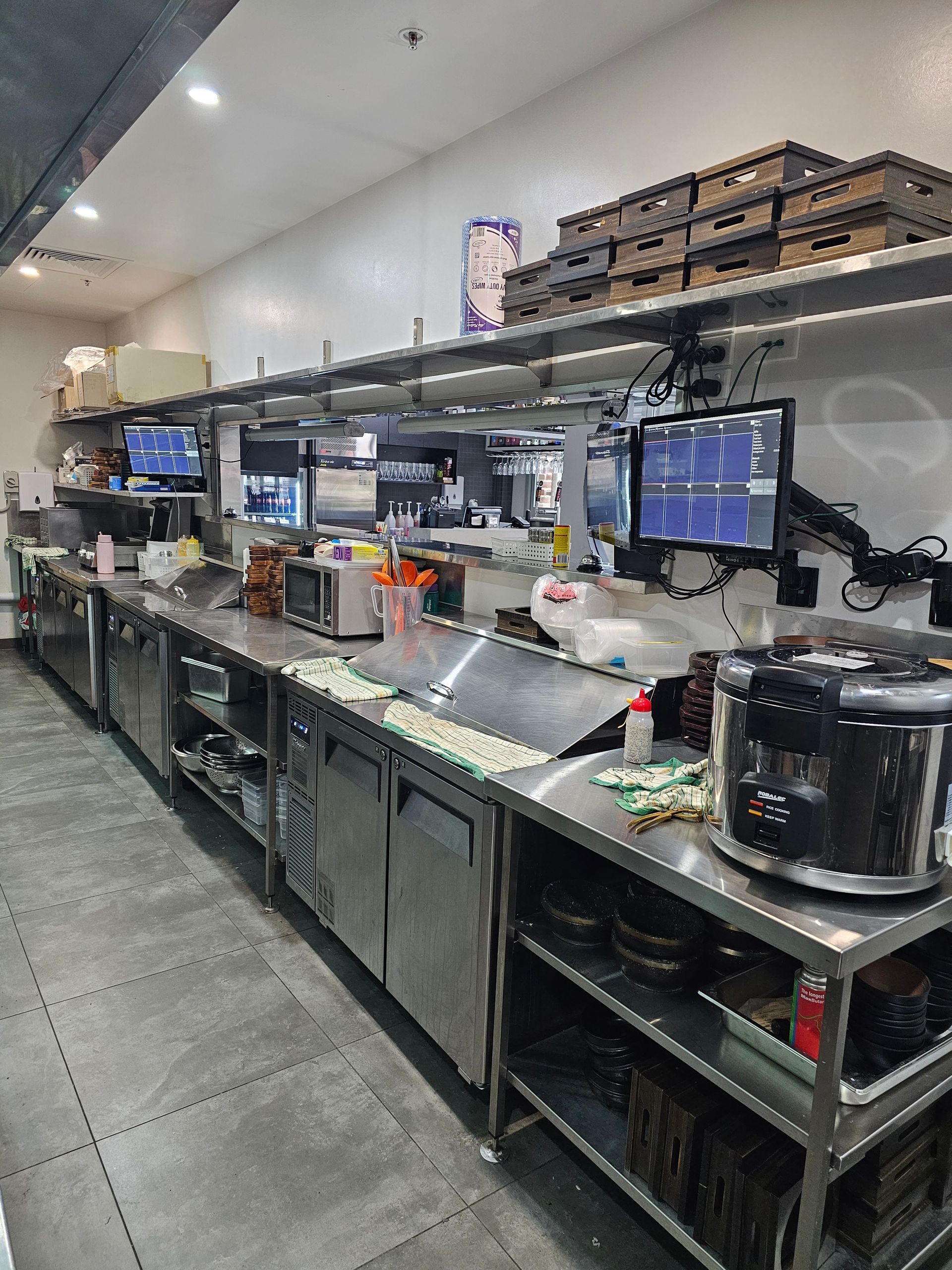A kitchen with a lot of stainless steel appliances and shelves.