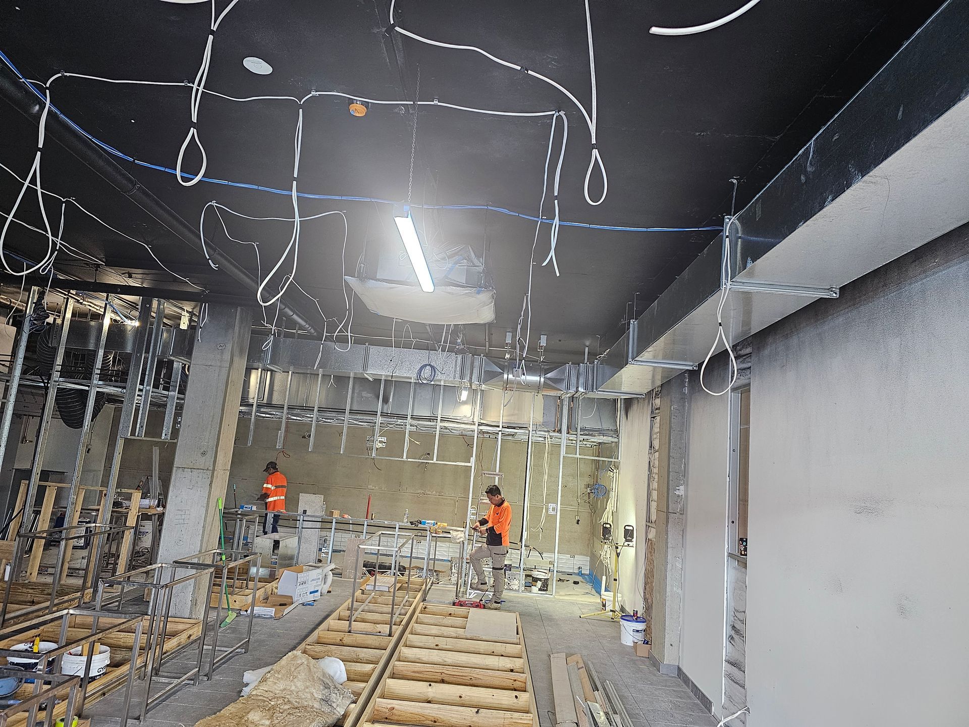 A building under construction with a lot of wires hanging from the ceiling.