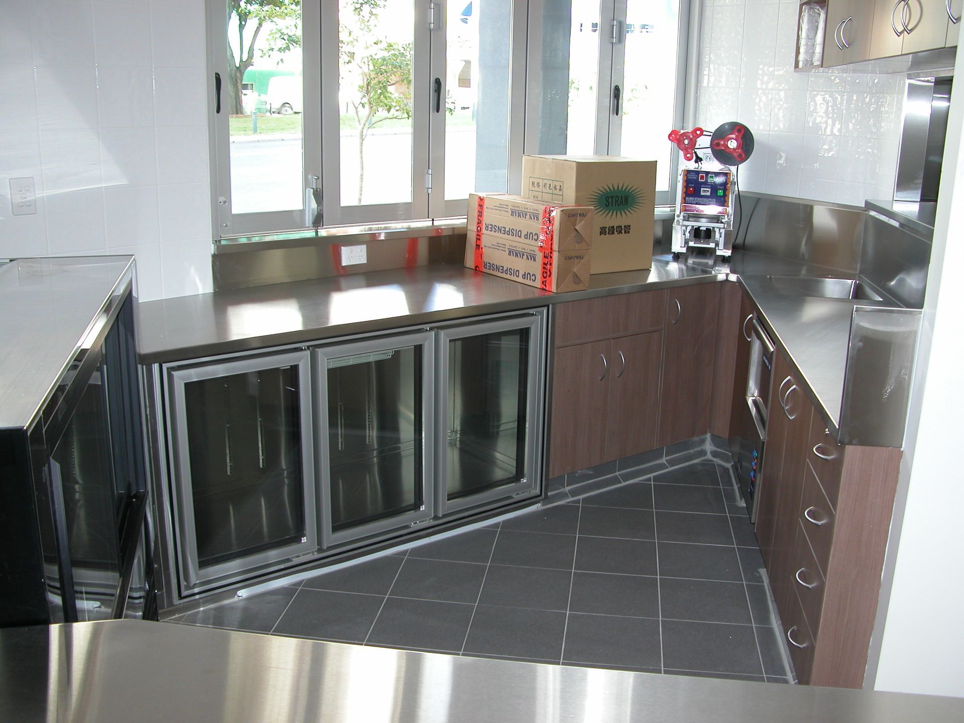 A kitchen with stainless steel cabinets and boxes on the counter