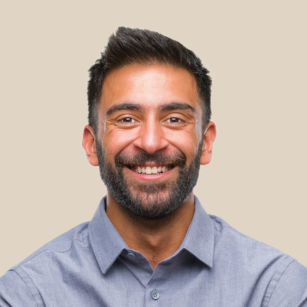 A man with a beard is smiling for the camera.