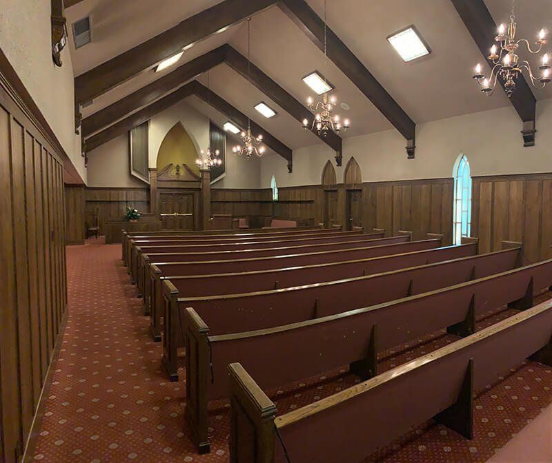 The inside of a church with rows of wooden benches